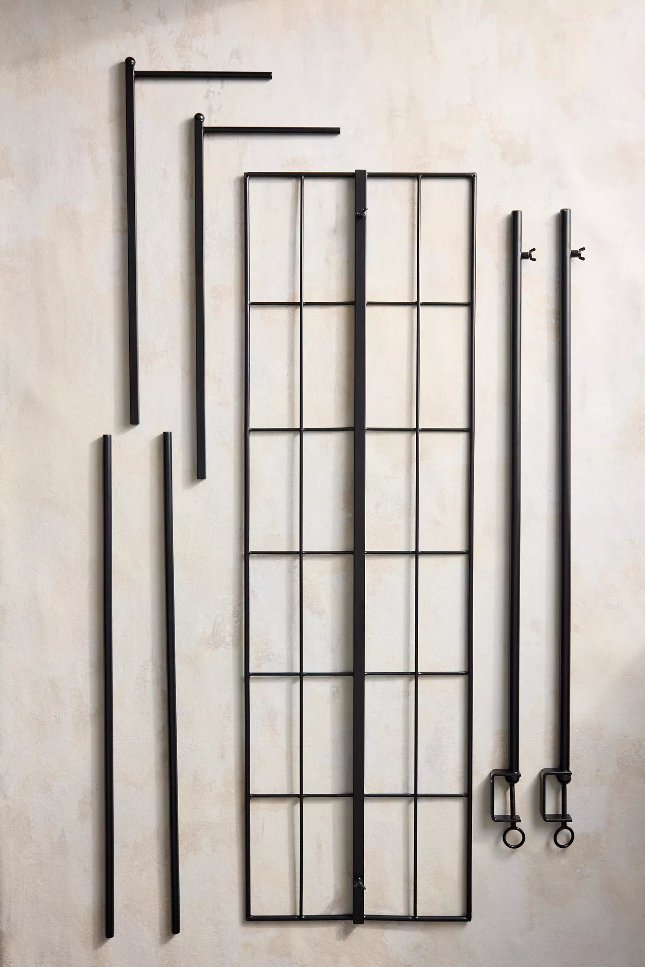 Disassembled metal frame pieces arranged on a wall
