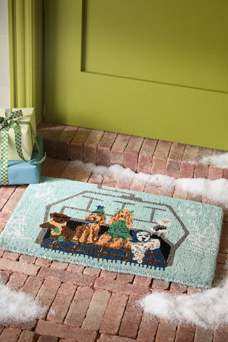 A blue doormat with five dogs on it in front of a green door