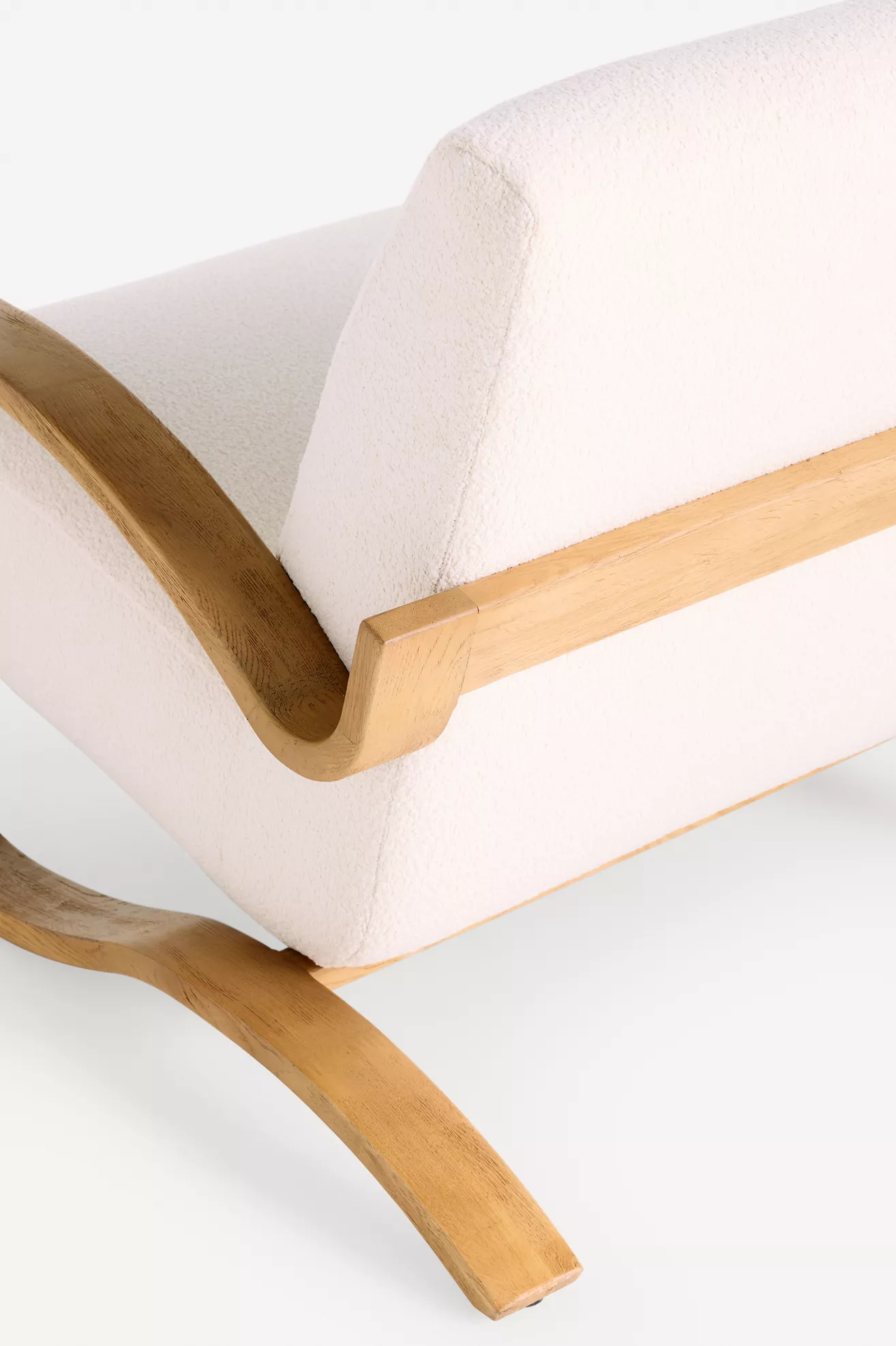 Close-up of the curved wooden arm support and upholstery edge