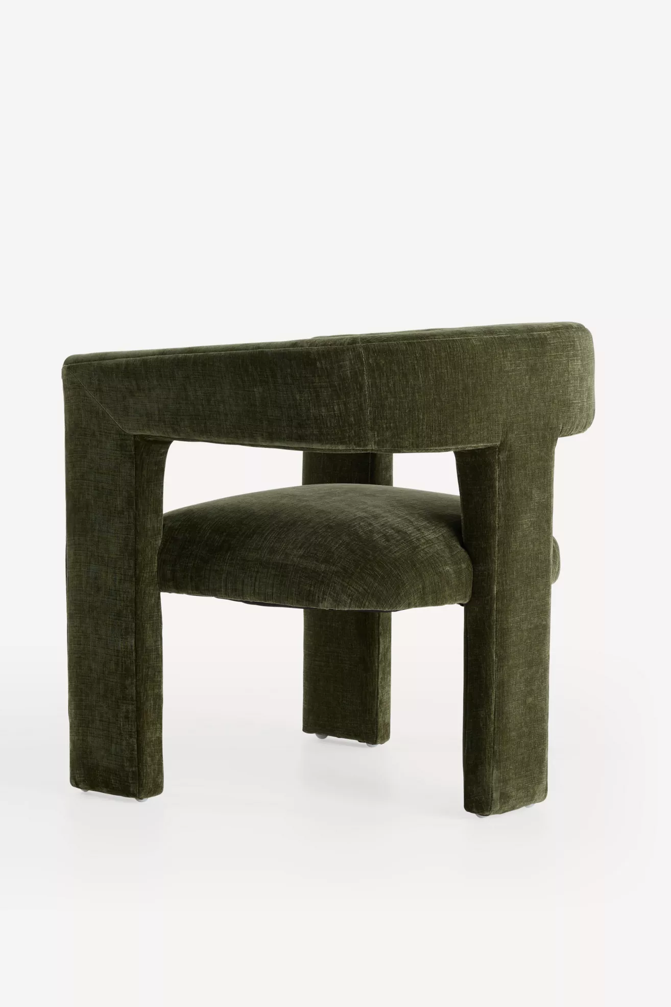 Three-quarter view of the green velvet dining chair
