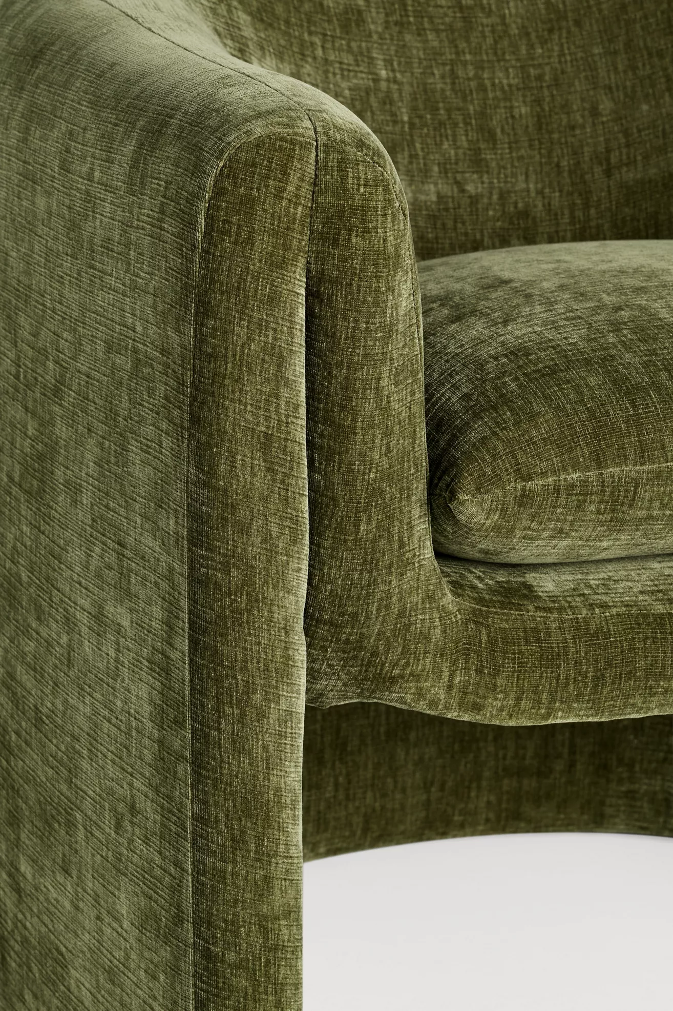 Close-up of upholsteried arm corner of olive green chair