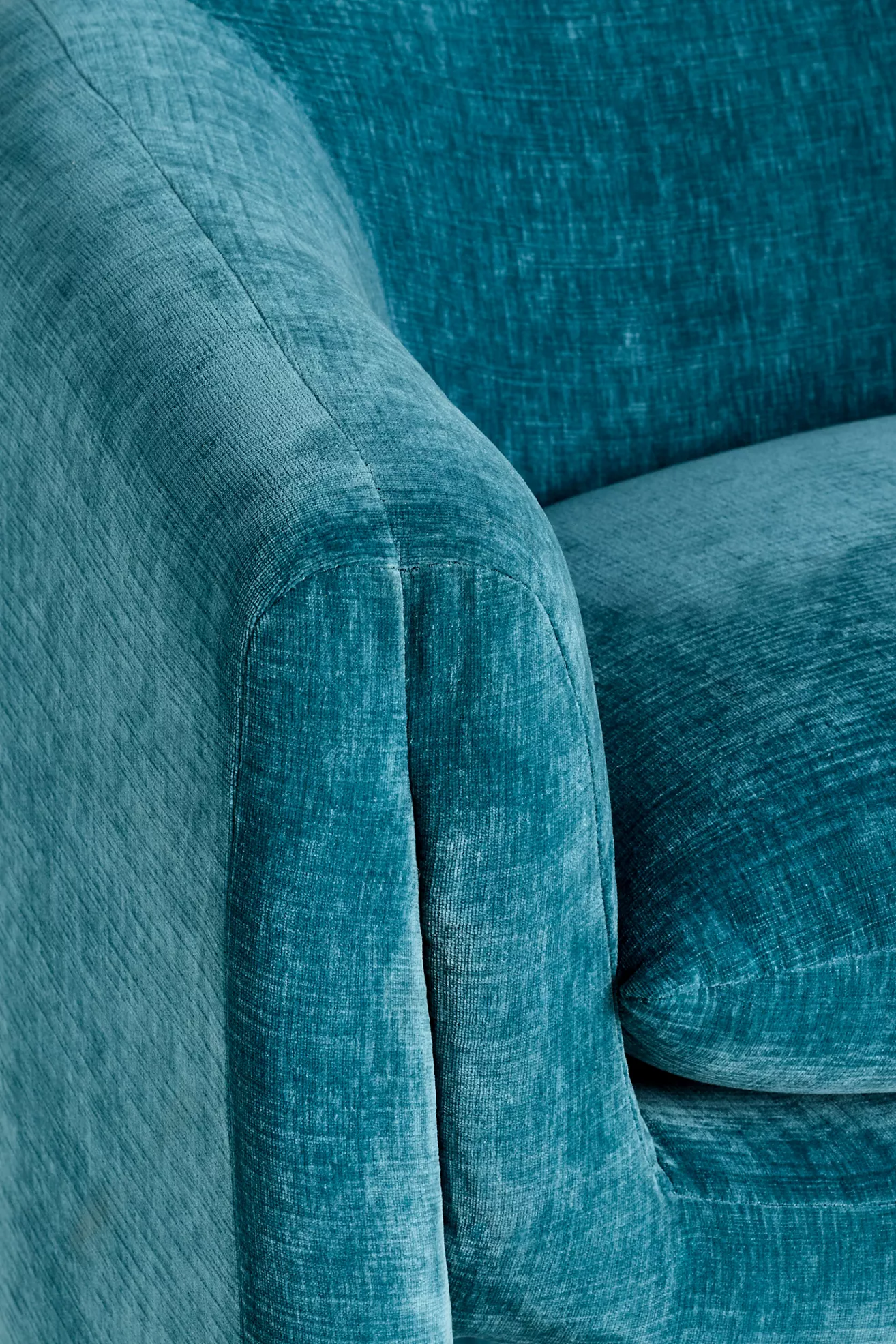Close-up of teal velvet upholstery on arm of chair