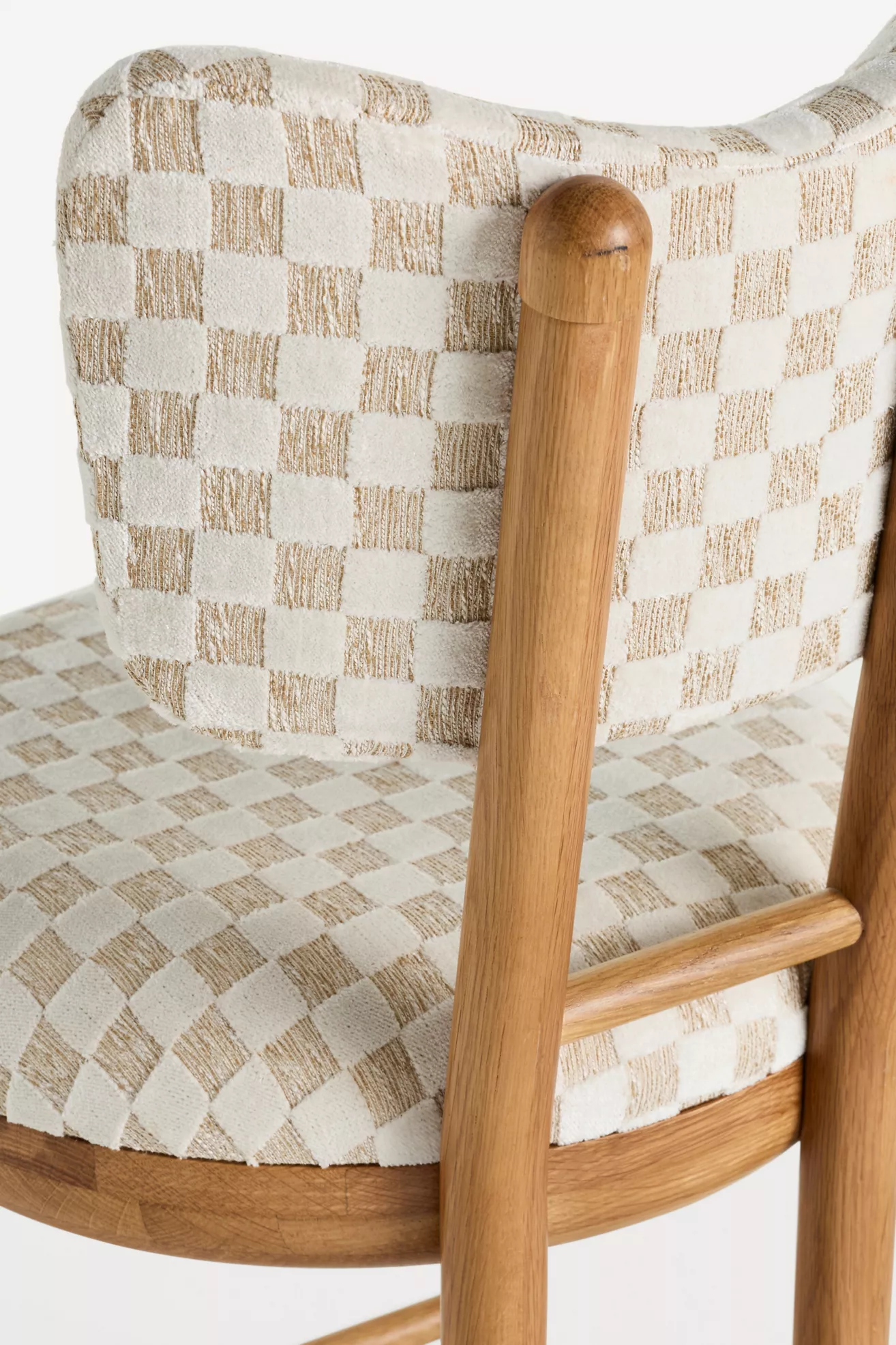 Close-up of wooden leg connection and upholstery pattern