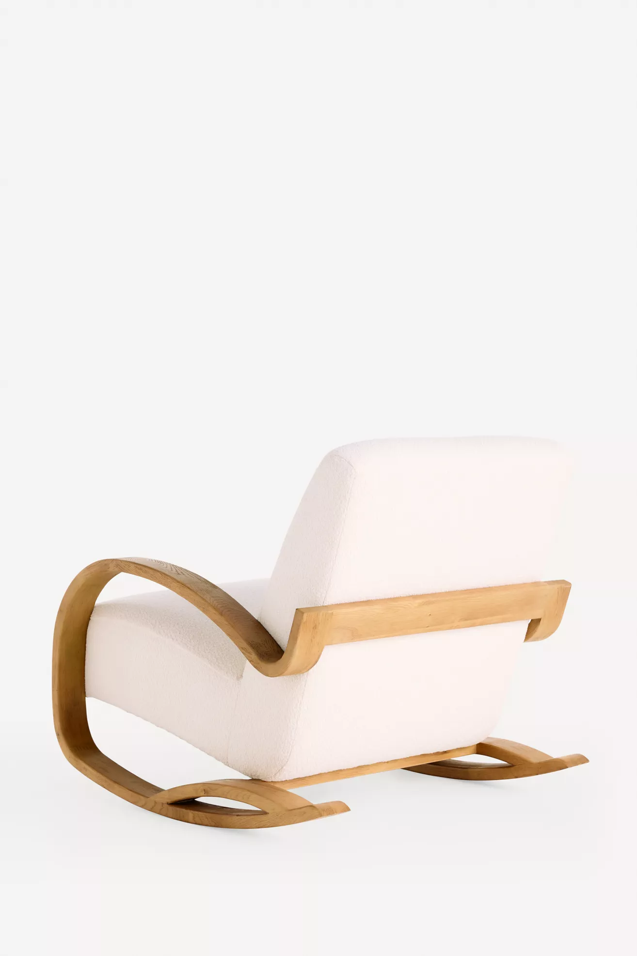 Rear three-quarter view of white upholstered rocking chair with wooden frame