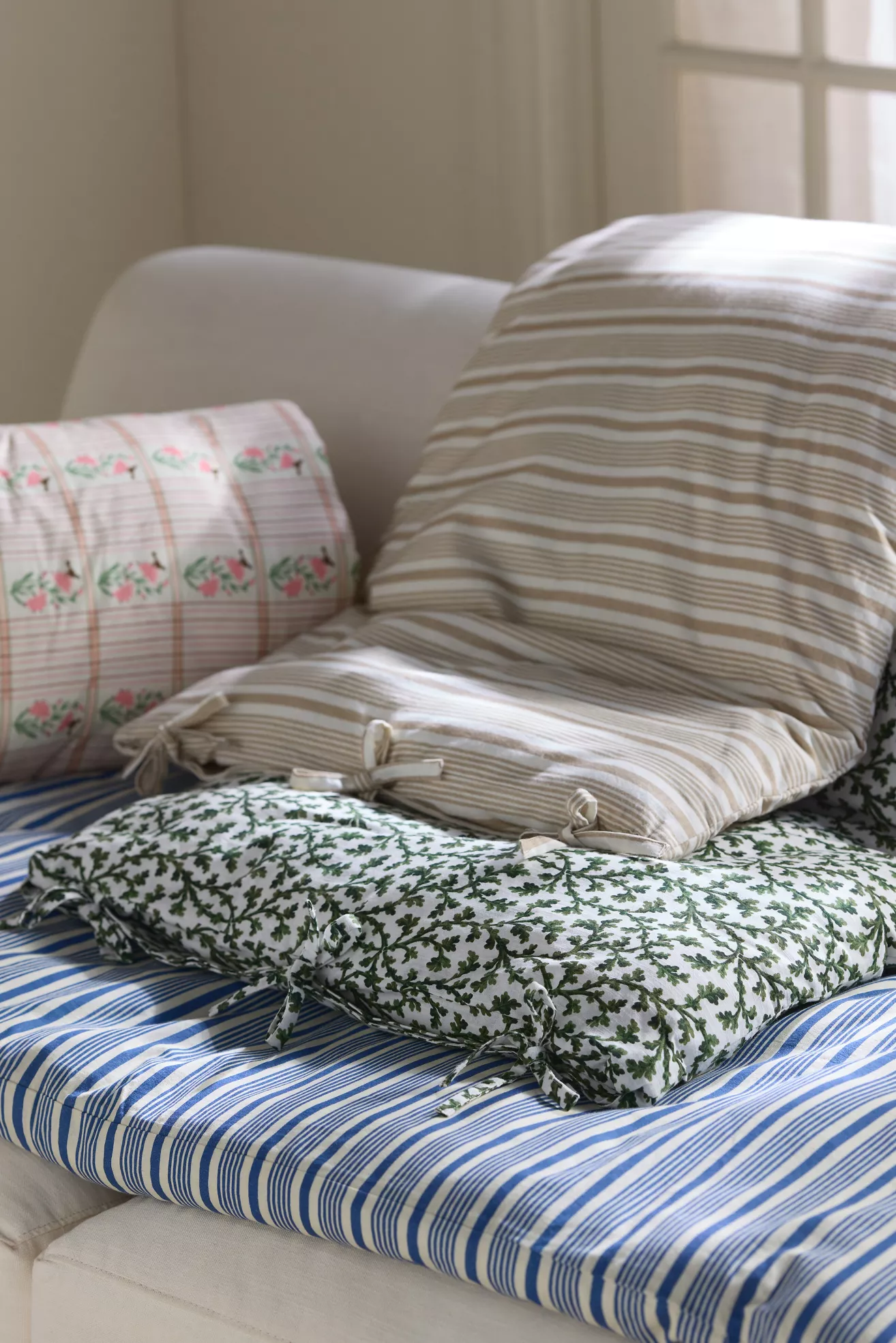 Striped sofa topper layered with patterned cushions