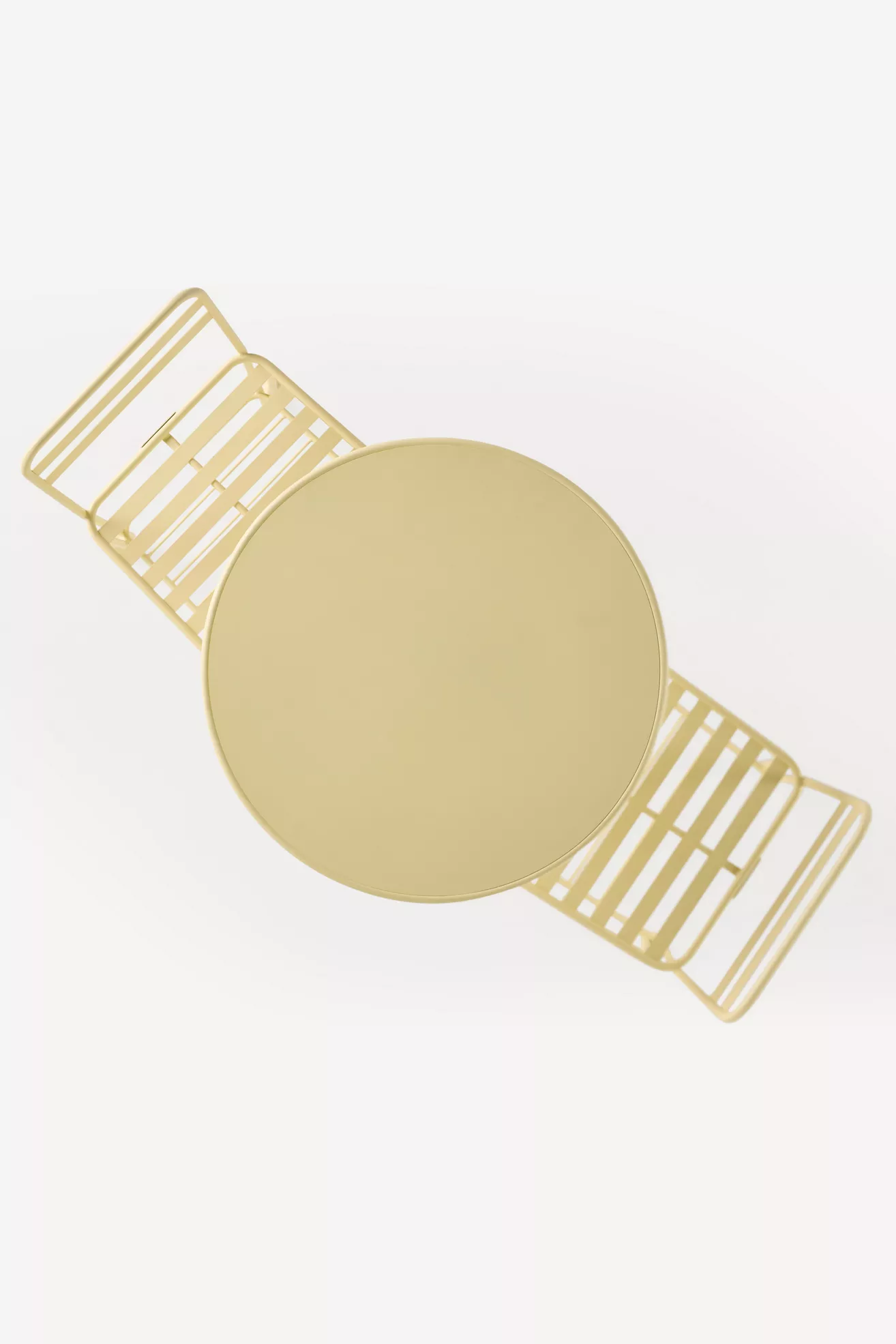Top-down view of round table surface with wire chair backs