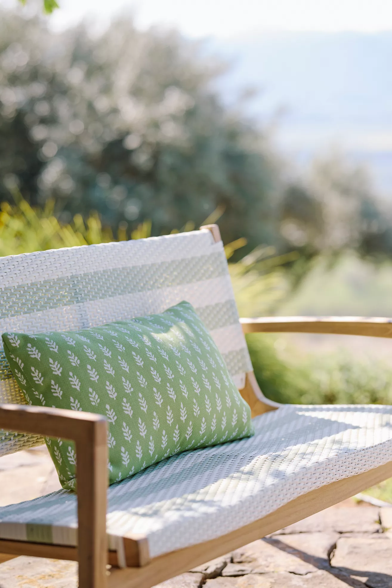 Green leaf-pattern cushion on white-woven sofa