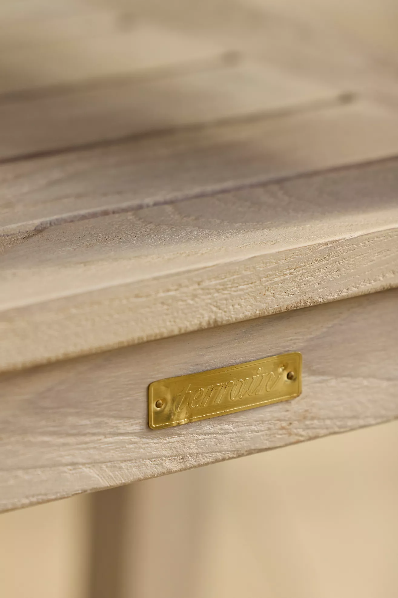 Gold metal plate with brand name on wooden chair