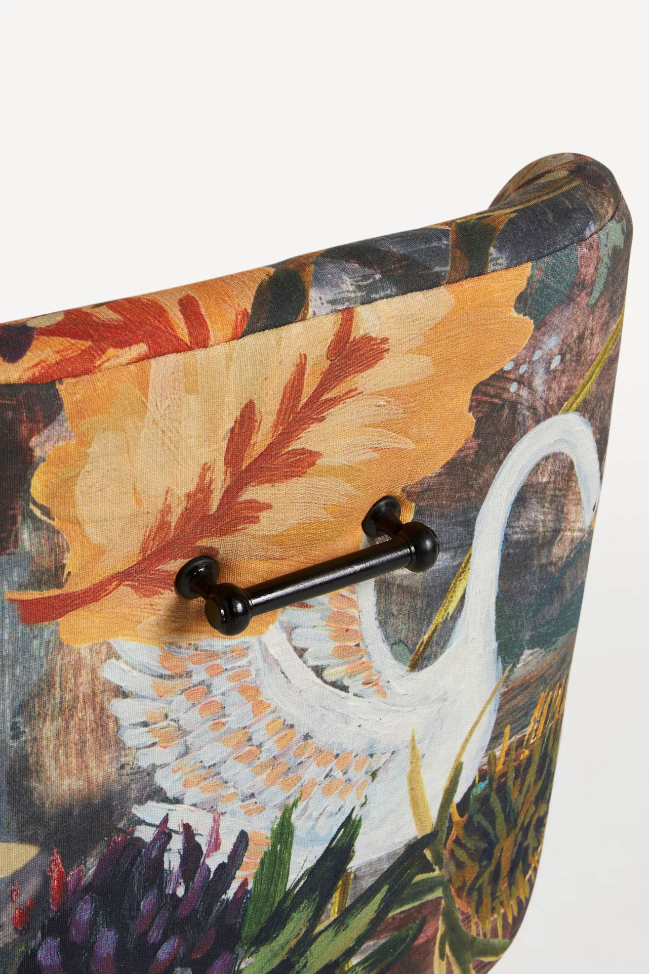 Close-up of chair back with black handle and printed fabric