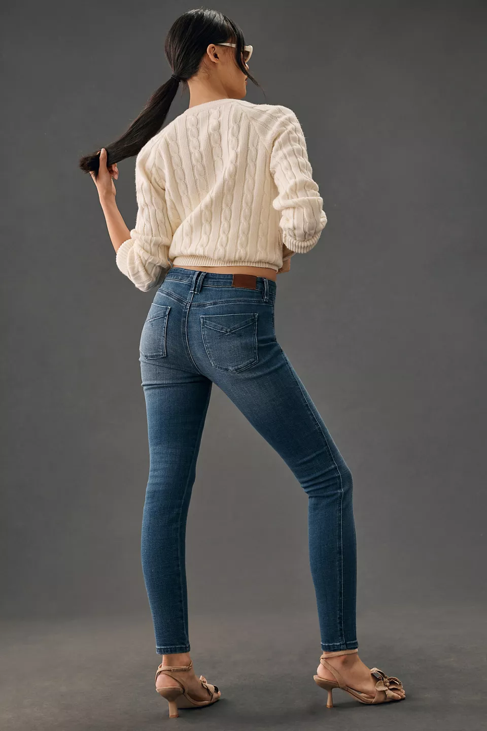Cream cable-knit sweater with dark skinny jeans and ankle boots