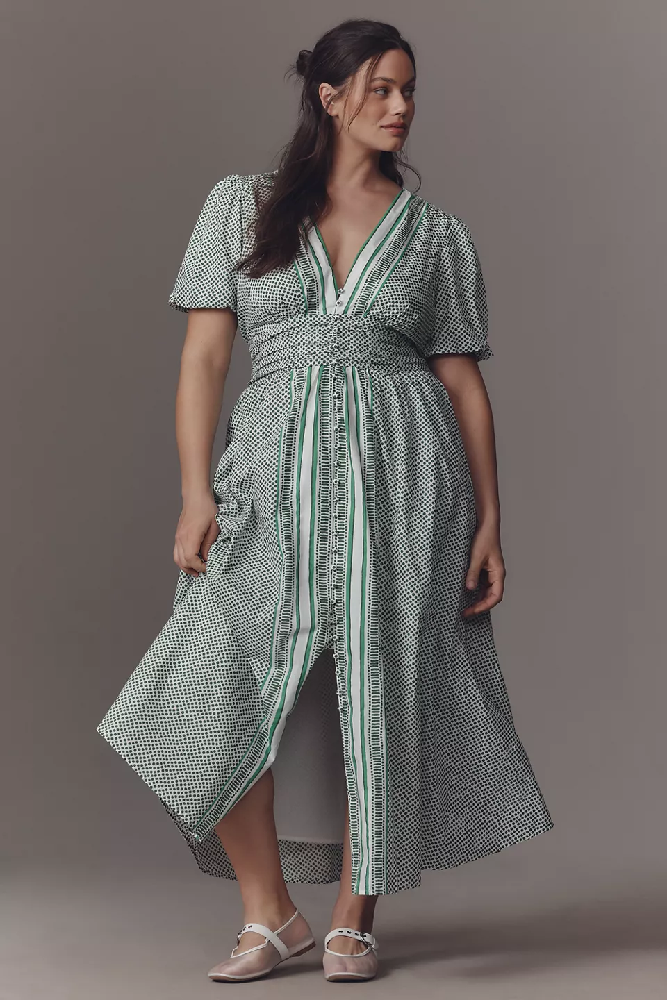 A plus-size, white-and-green polka dot dress with white-and-green striped trim