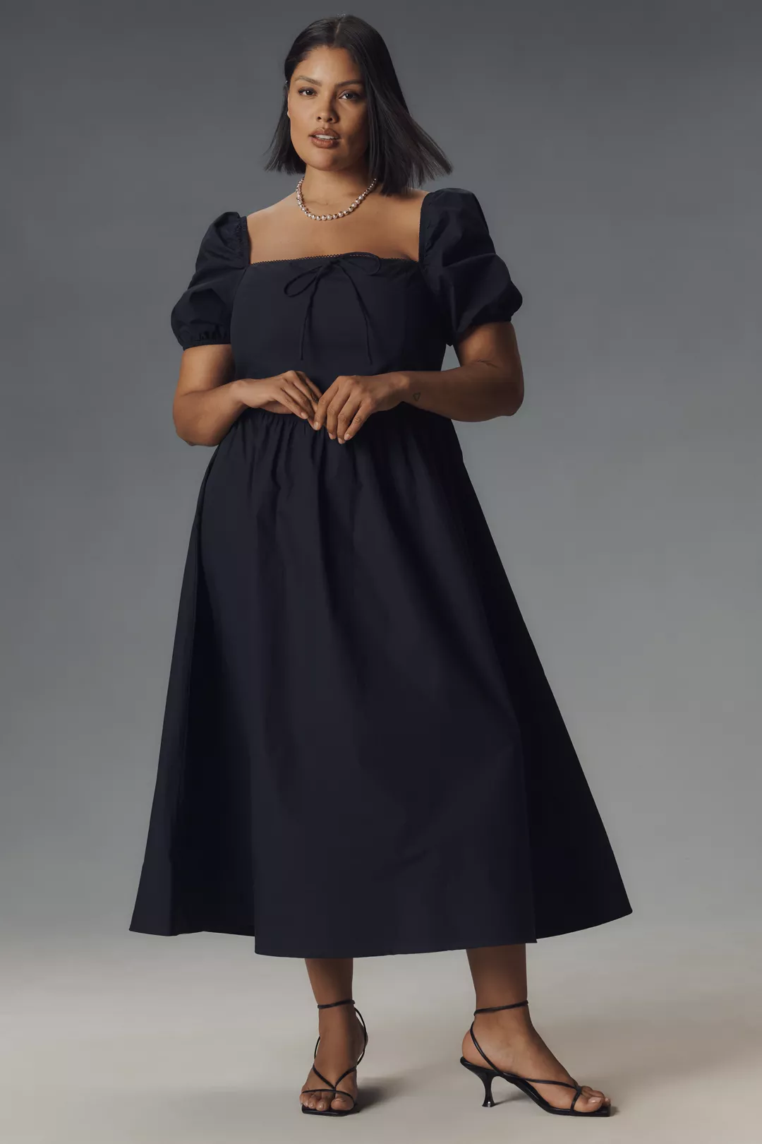 A plus-size, navy, puff-sleeve milkmaid midi dress