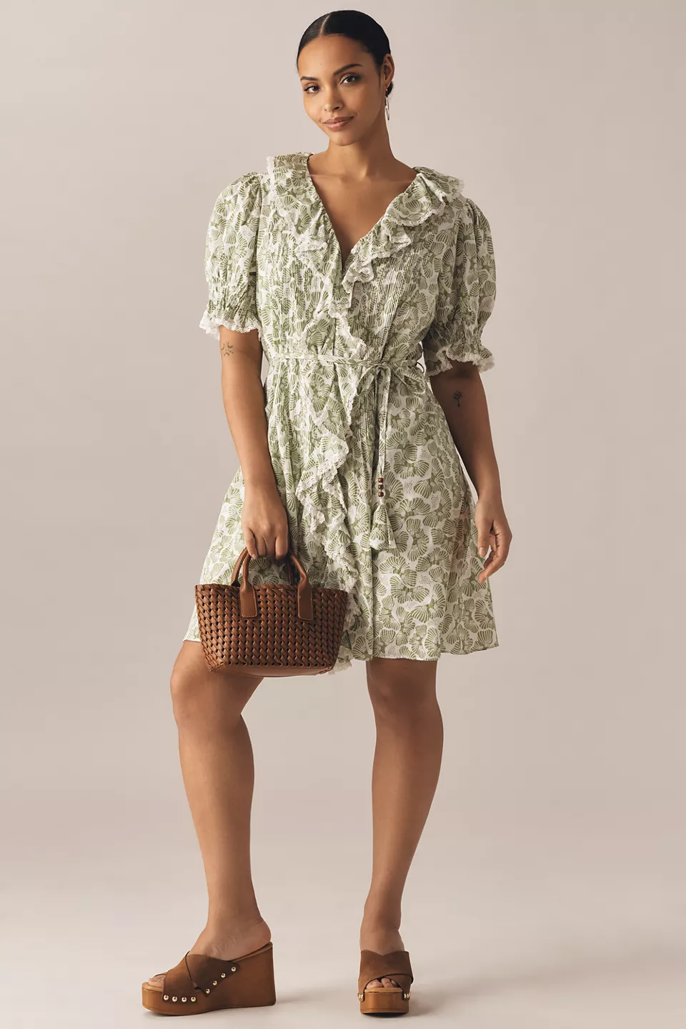 A plus-size, green-and-white printed mini dress with puff sleeves, ruffles, and a cinched waist