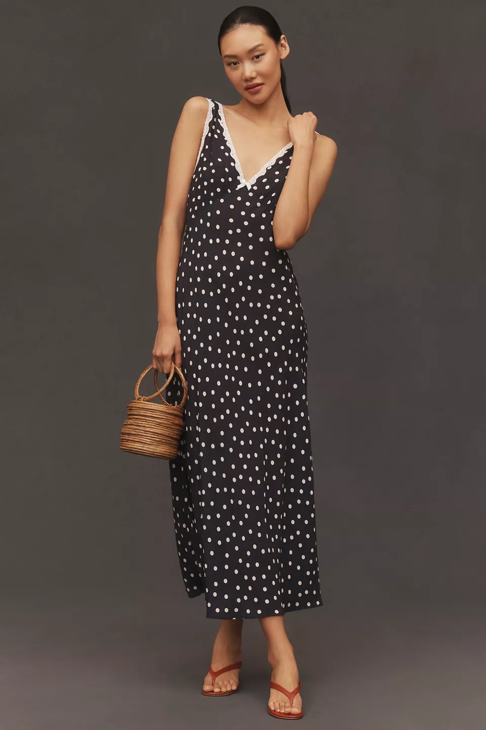 A black midi dress with white polka dots, white lace trim, and a white bow
