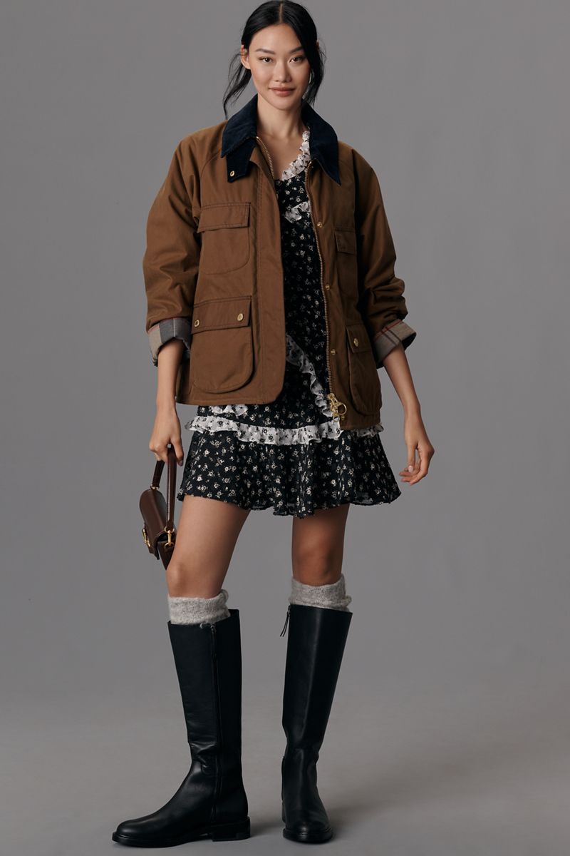 Brown barn jacket worn over a floral dress with tall black boots