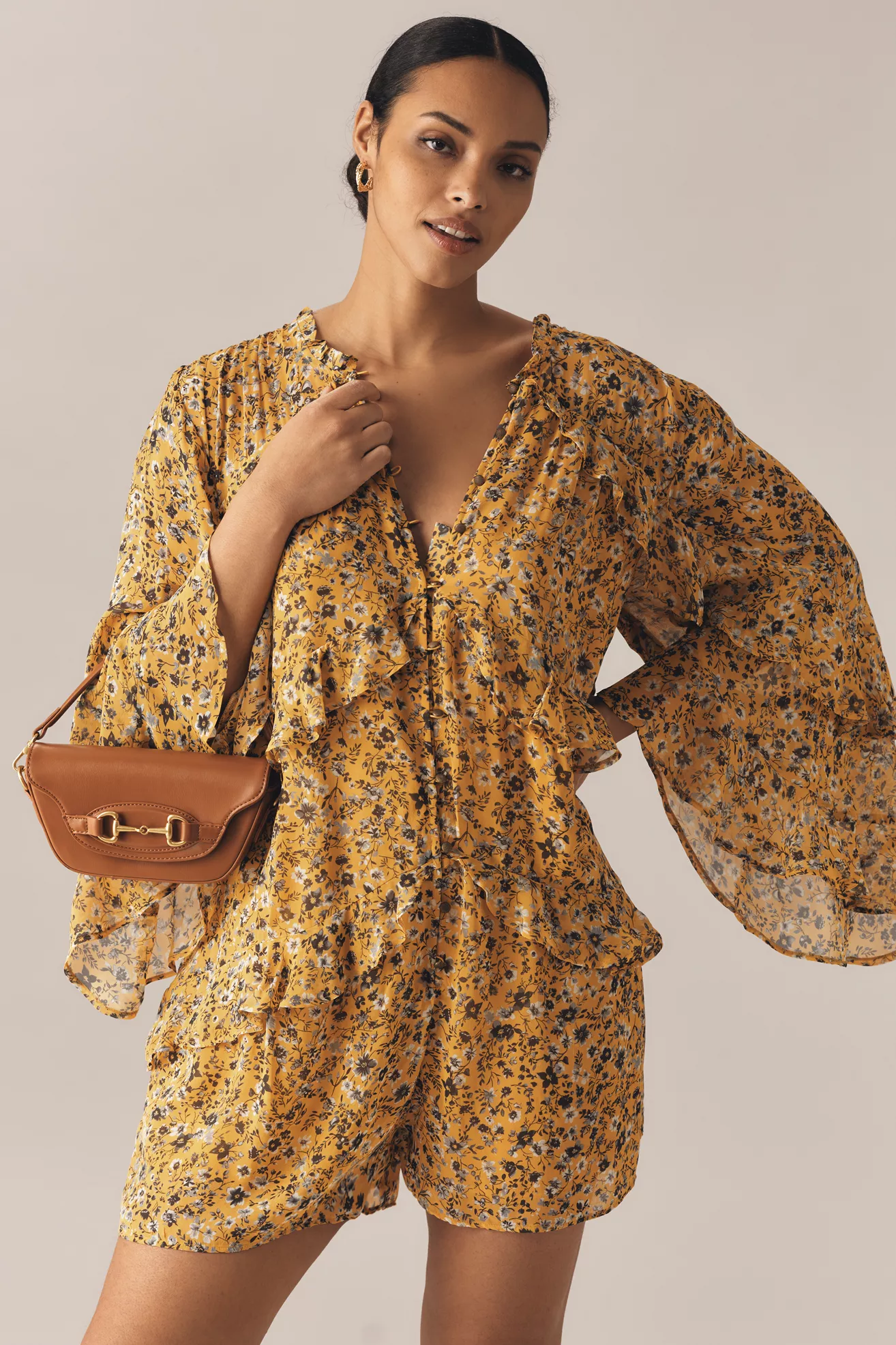 A plus-size, yellow floral, flowy romper