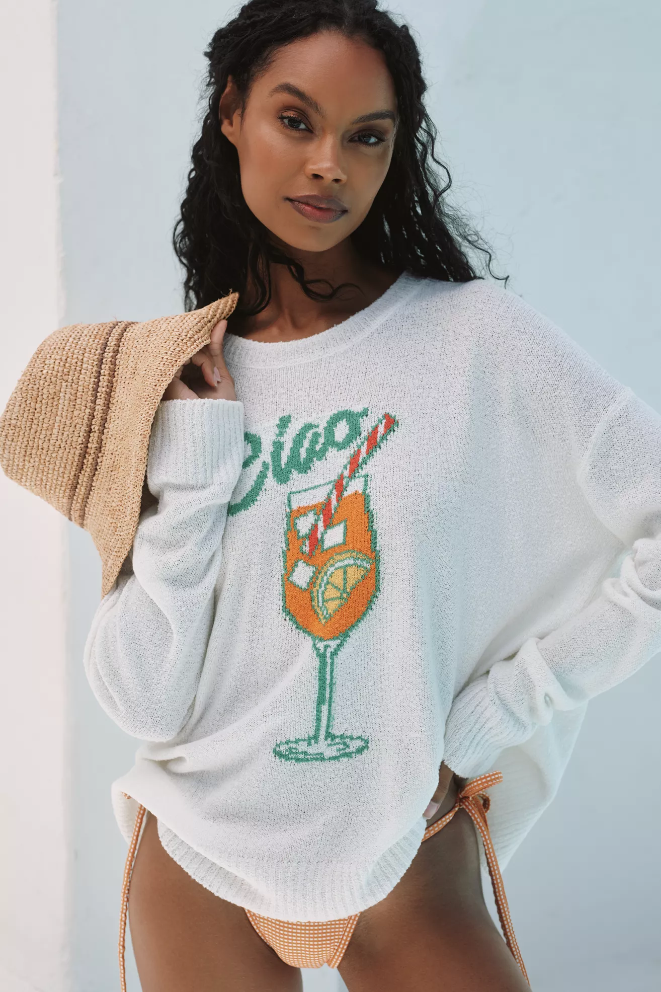 A plus-size, white, beach sweater that says "ciao" with a cocktail