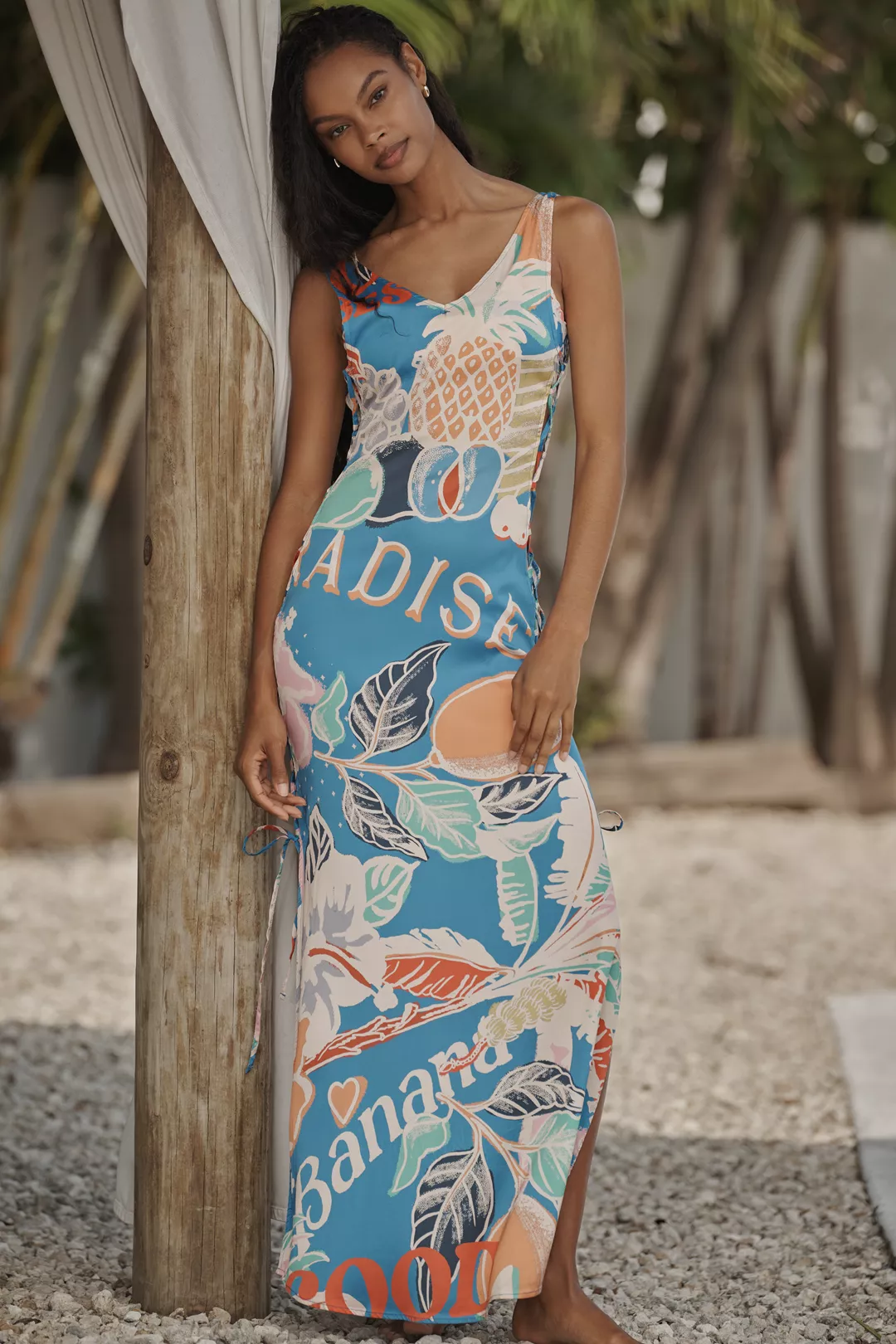 A light-blue maxi dress printed with pineapples, lemons, and words