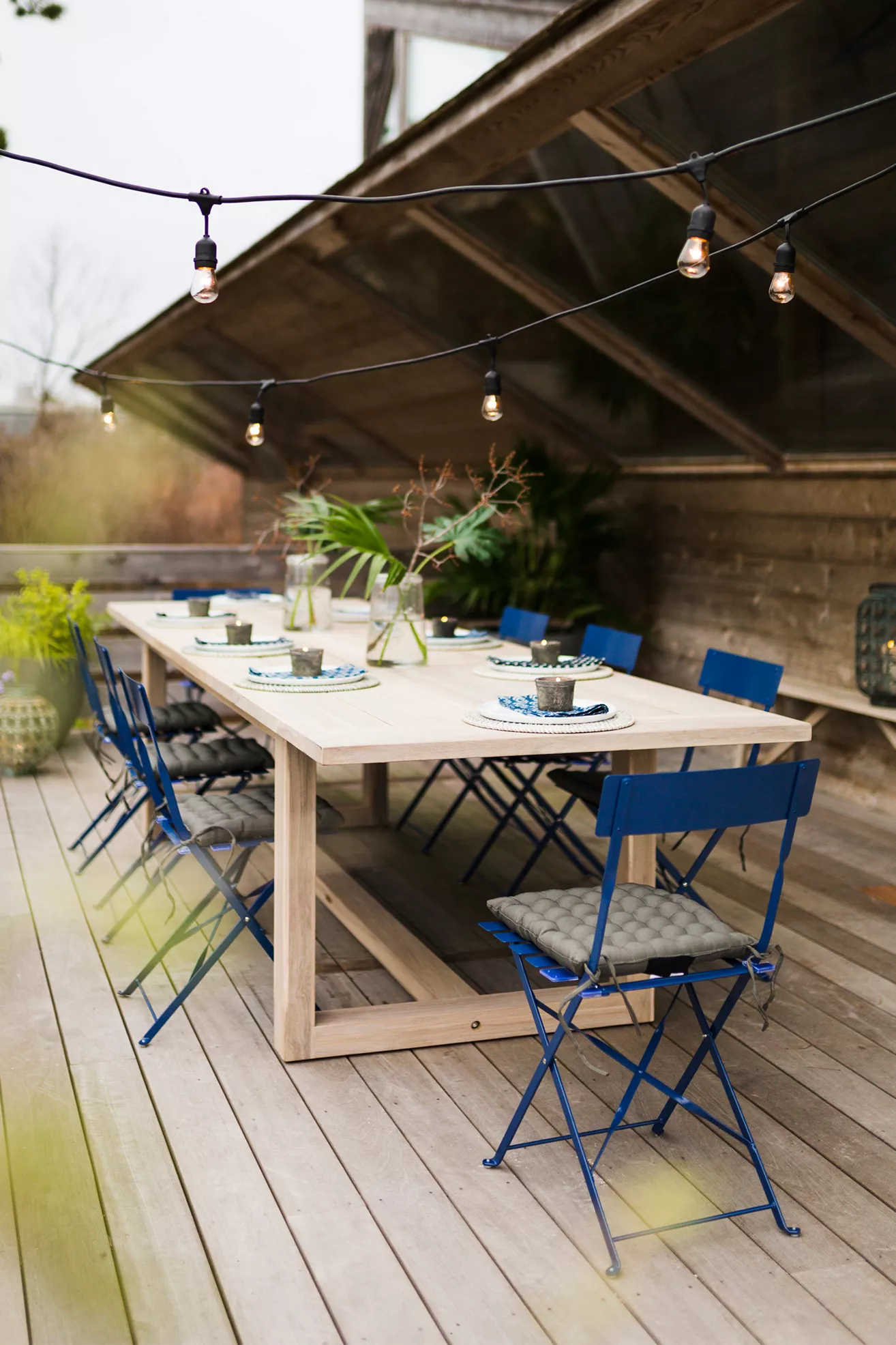 Table set outdoors with string lights