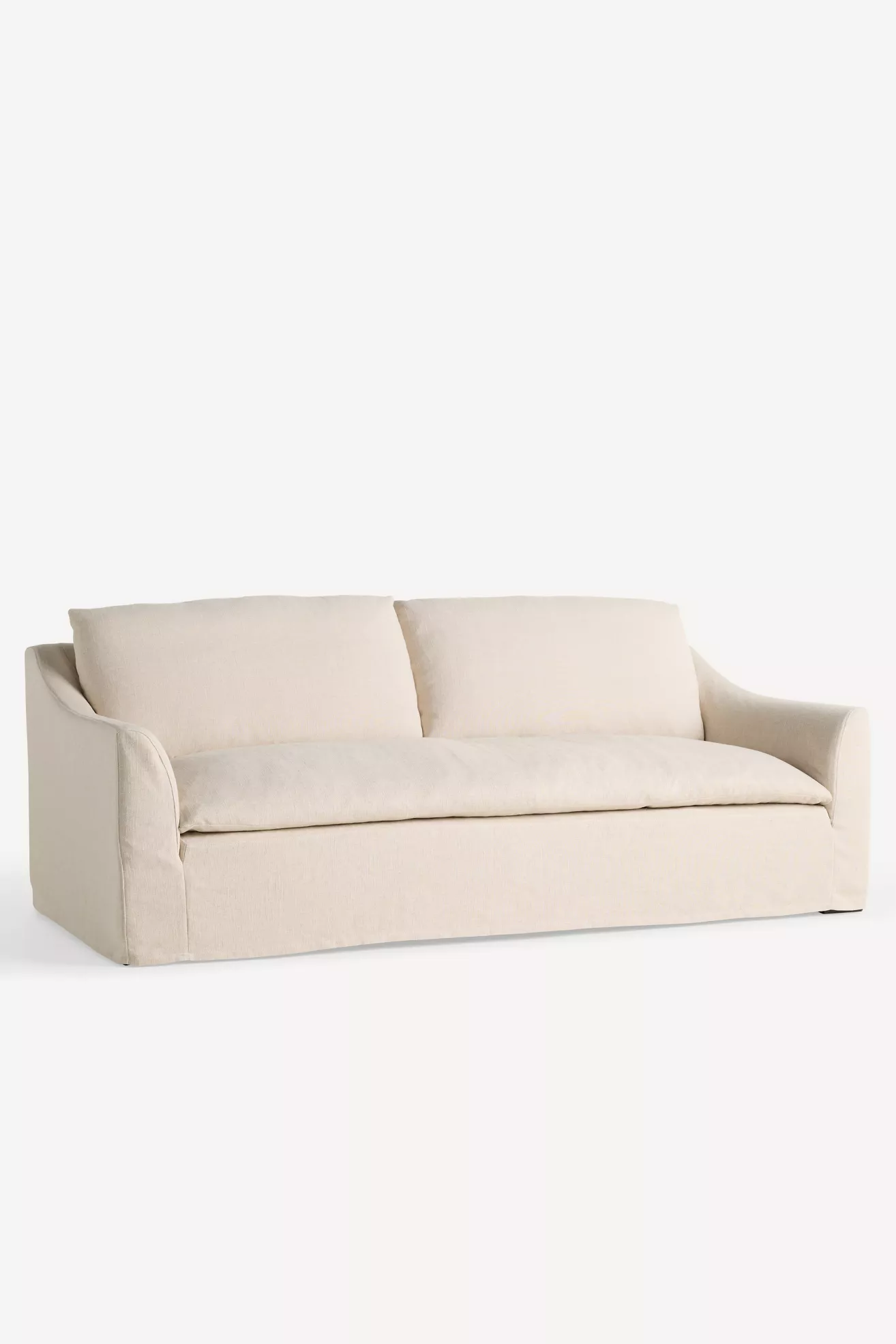 Beige slipcovered sofa shown from angled front