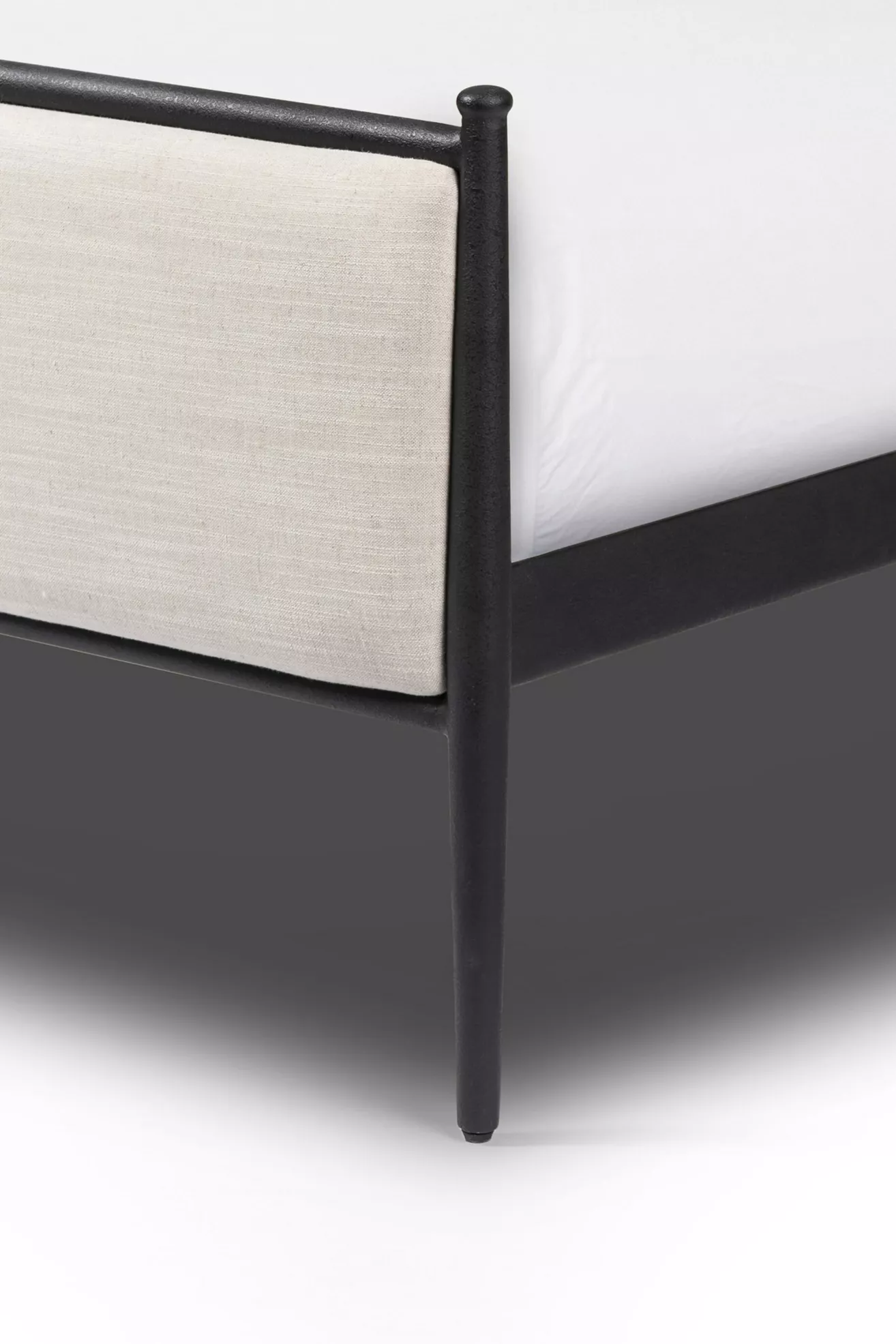 Close-up of one bedpost and upholstered panel