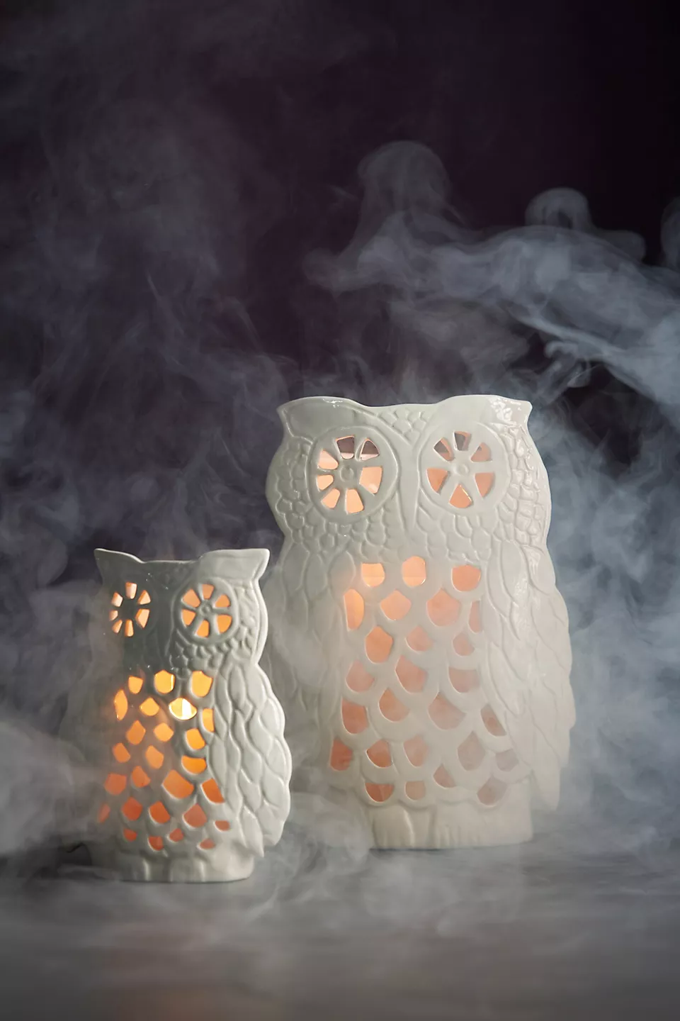 A white ceramic stoneware Francesca Kaye Halloween Magic Owl Lantern with a glowing candle inside 