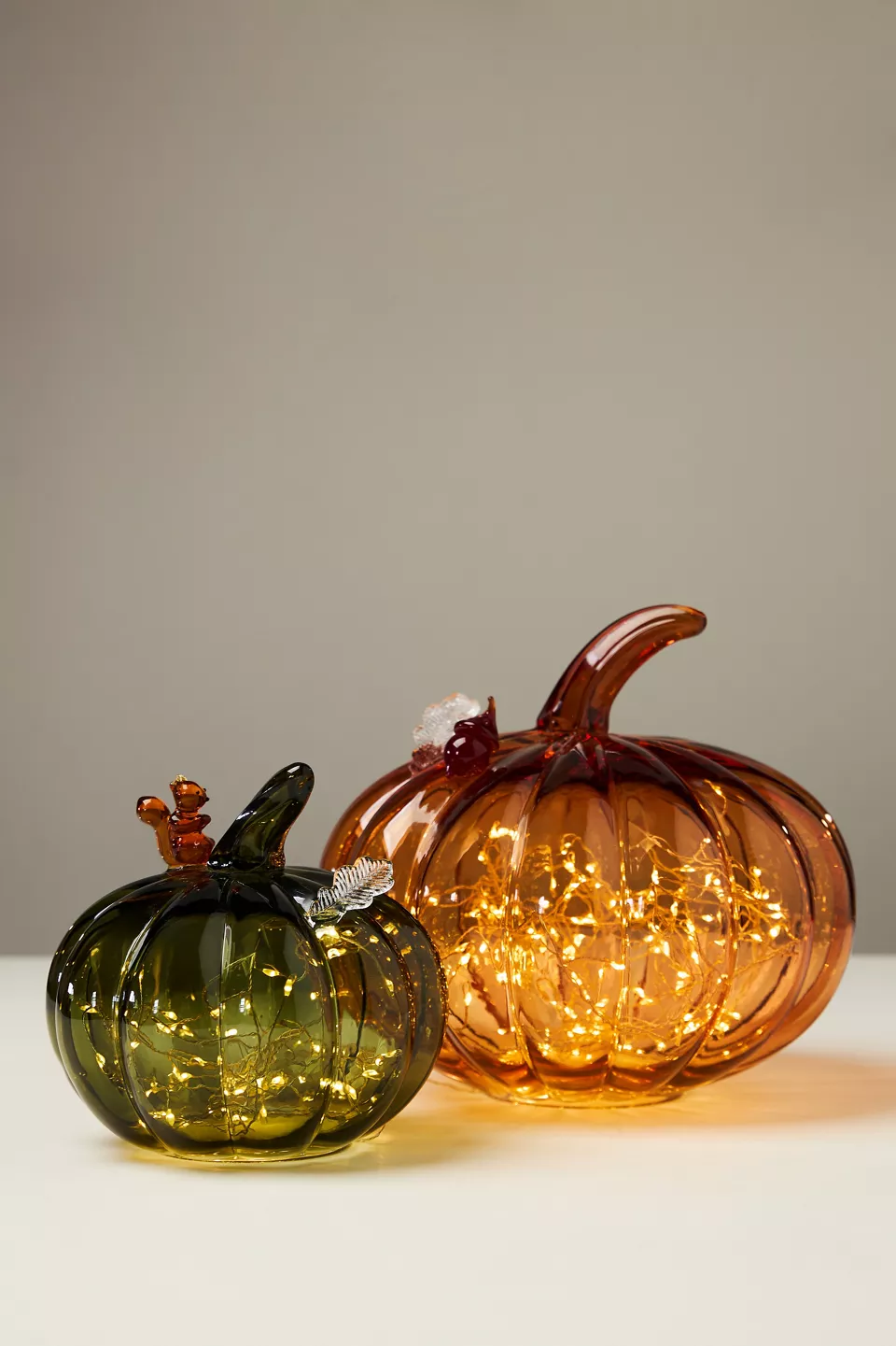 A green and an orange glass pumpkin decoration
