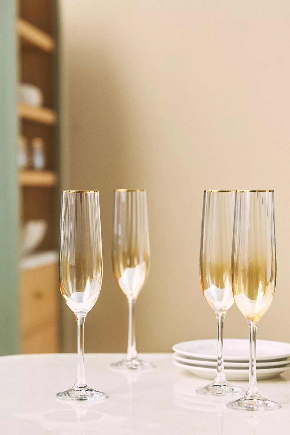 Four gold tinted glass champagne flutes on a table