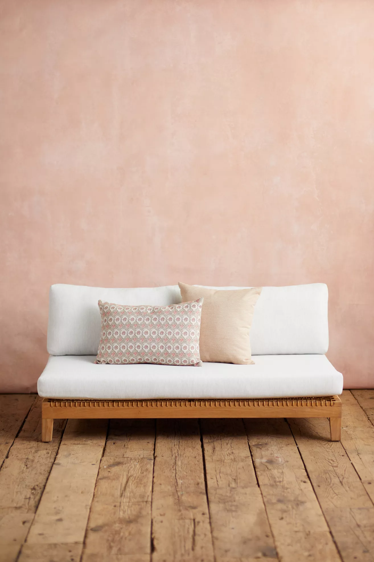 white sofa with two back cushions and two beige pillows
