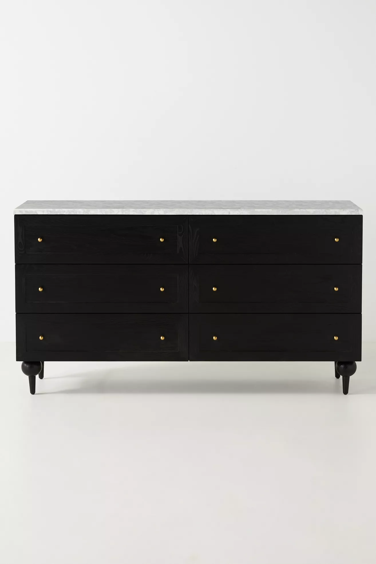 Black six-drawer dresser with marble top on a white background
