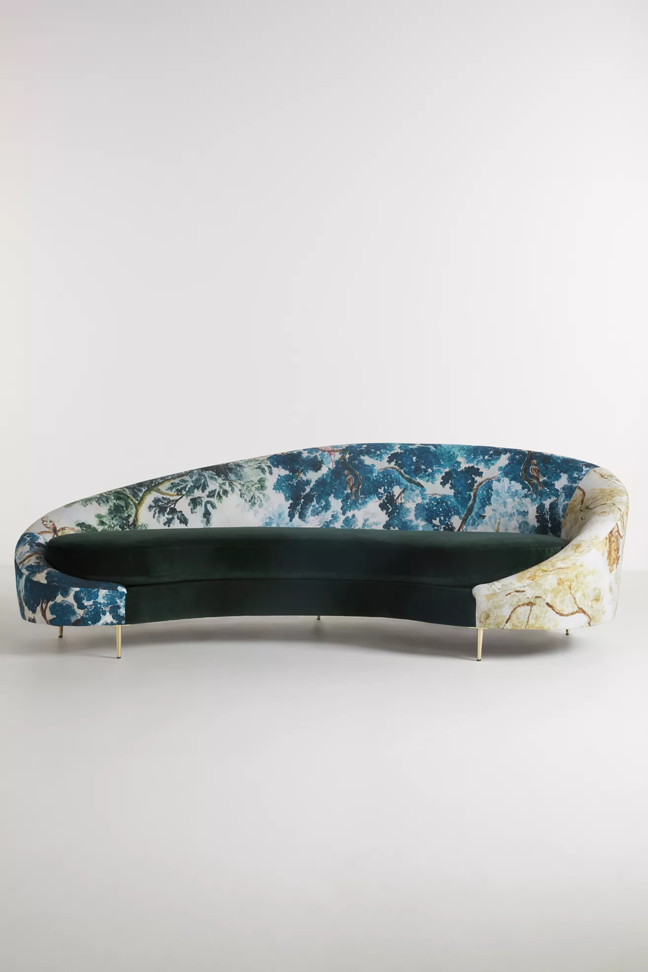 Side-front view of curved sofa showing botanical print fabric