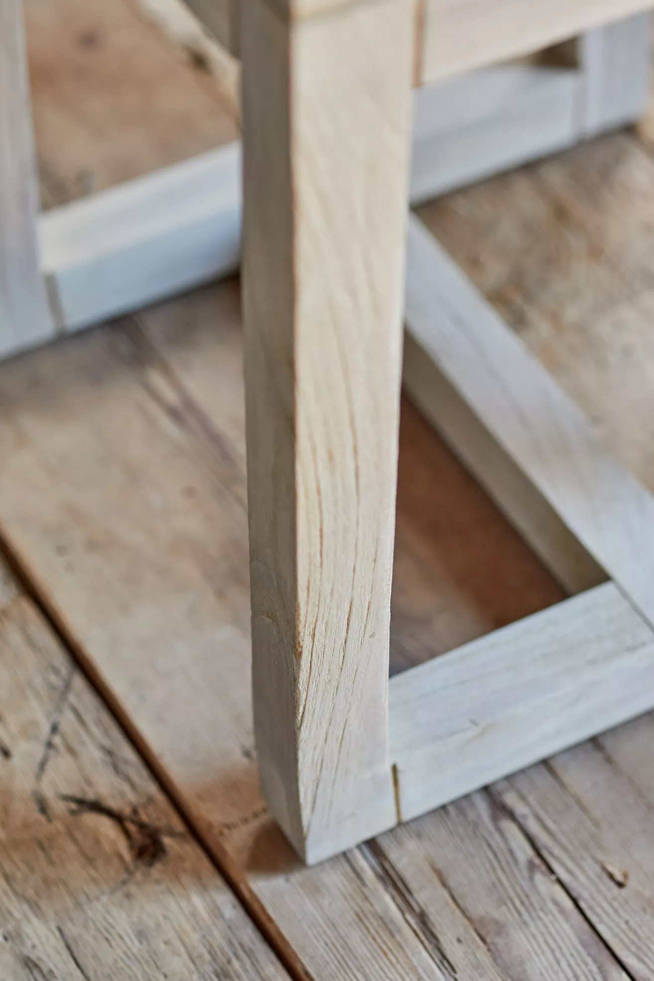 Close-up of a slatted leg of a wooden dining stool