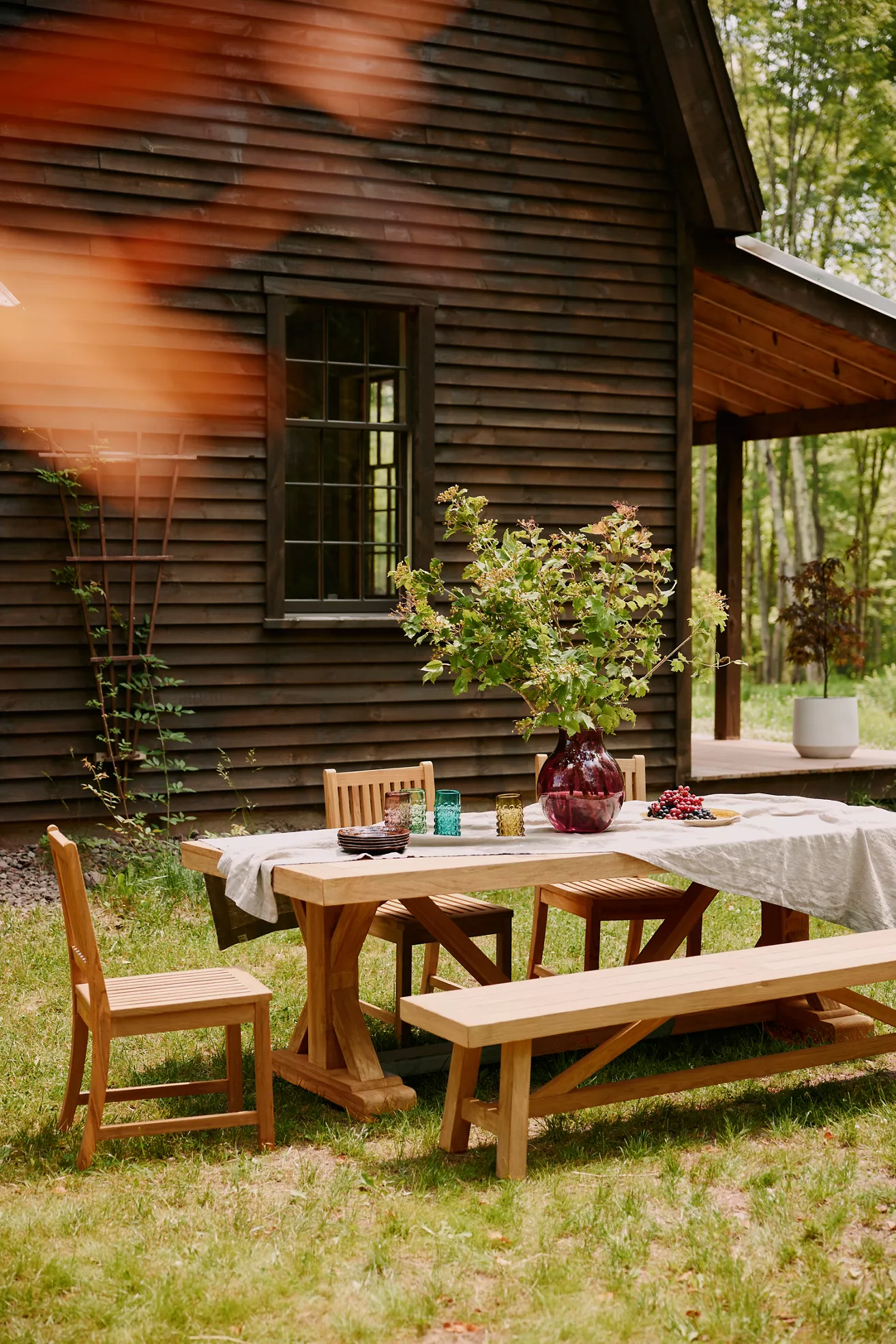 Outdoor dining set on grass with chairs and bench