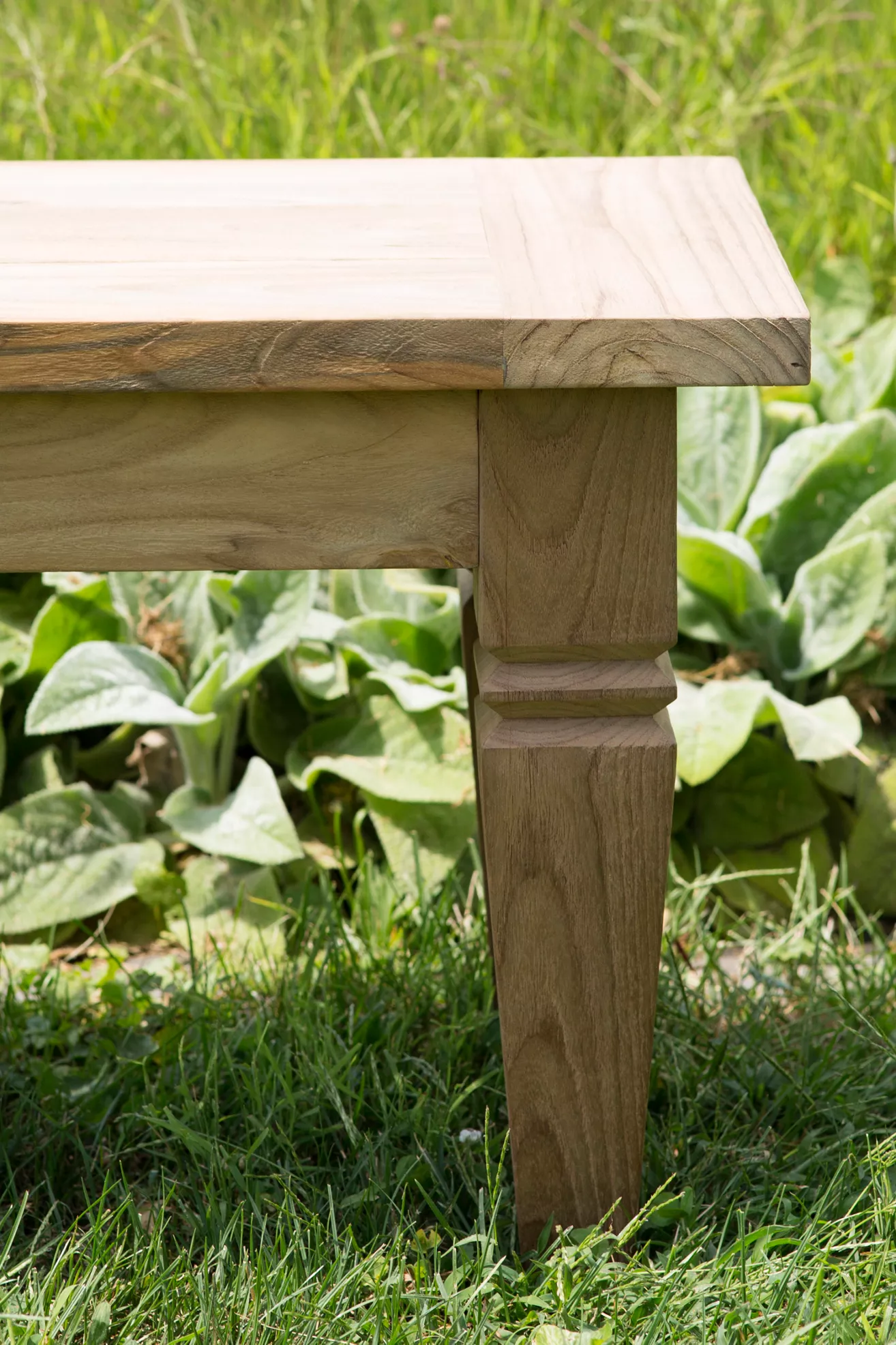 Close-up of teak dining bench leg and corner