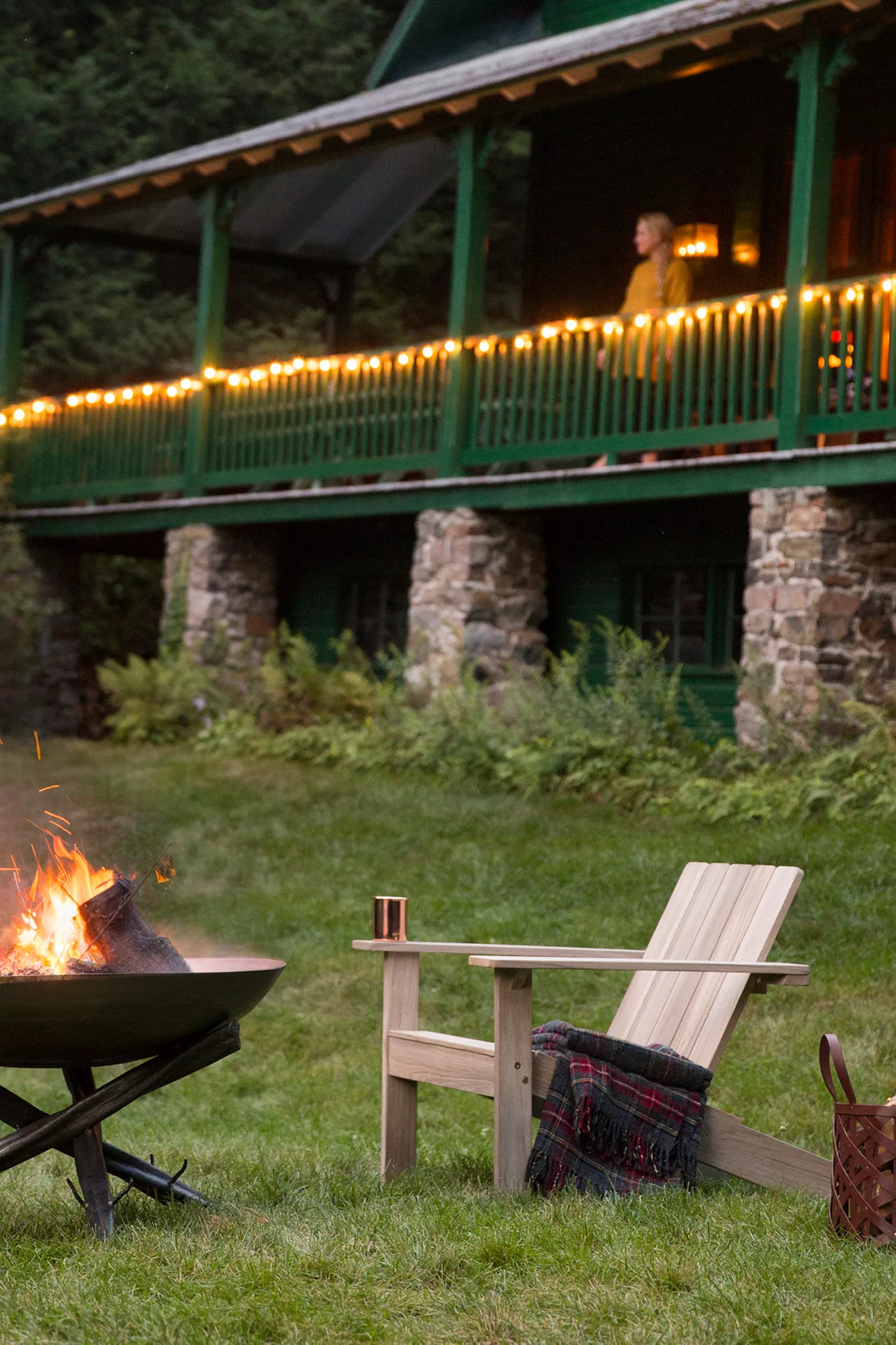Teak Adirondack chair set near fire pit with blanket