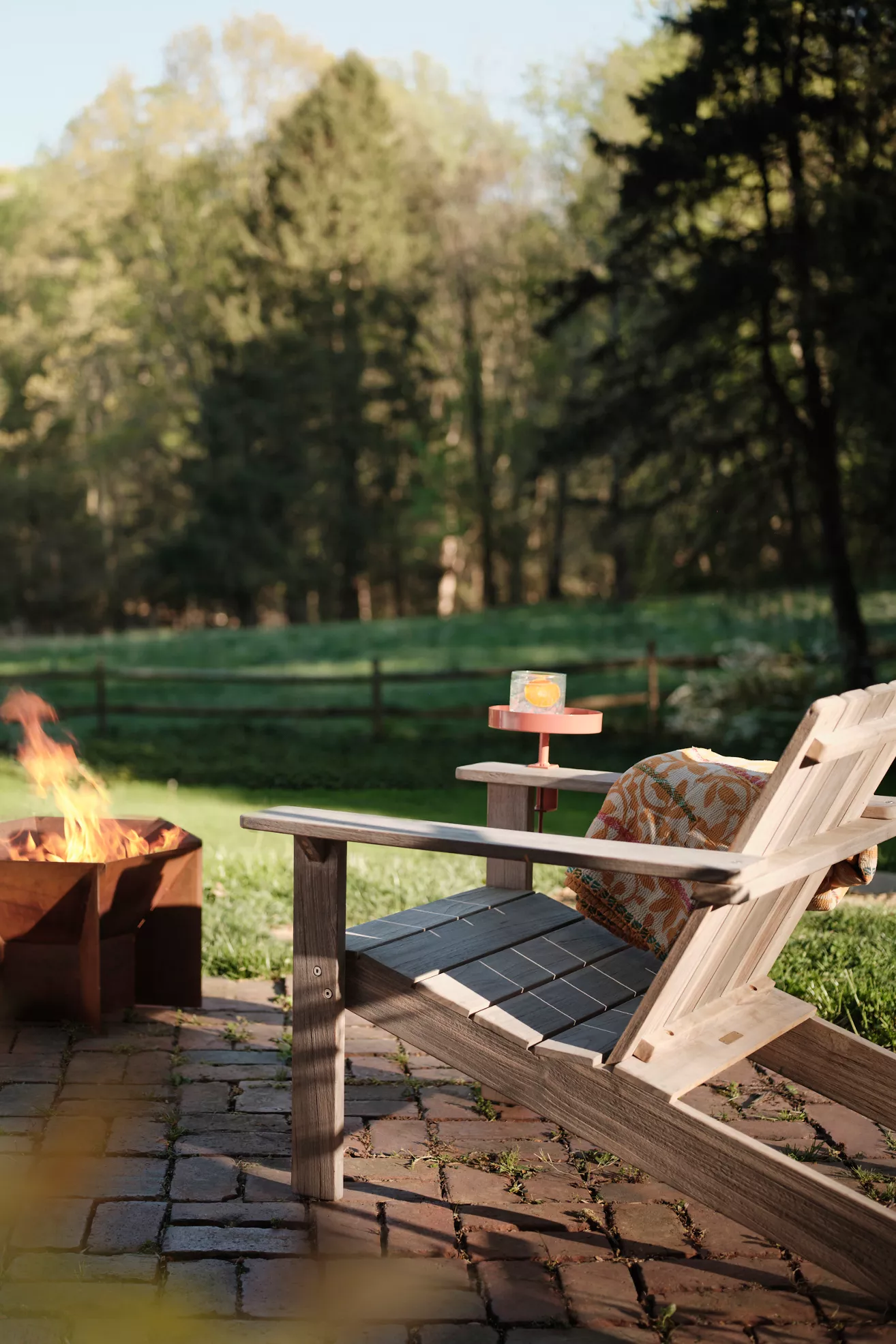Teak Adirondack chair on a patio with fire