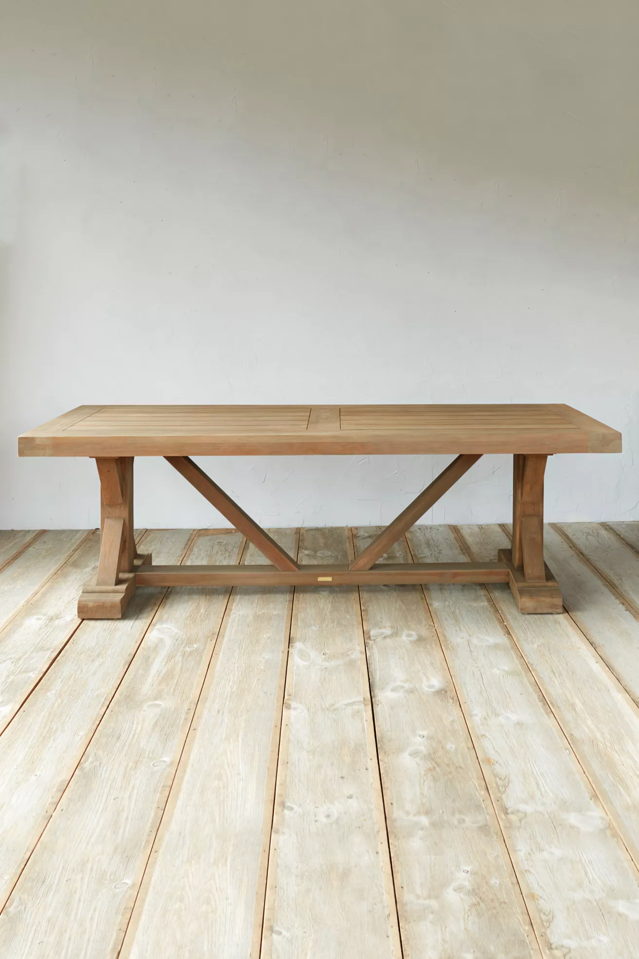Teak dining table with cross-brace legs