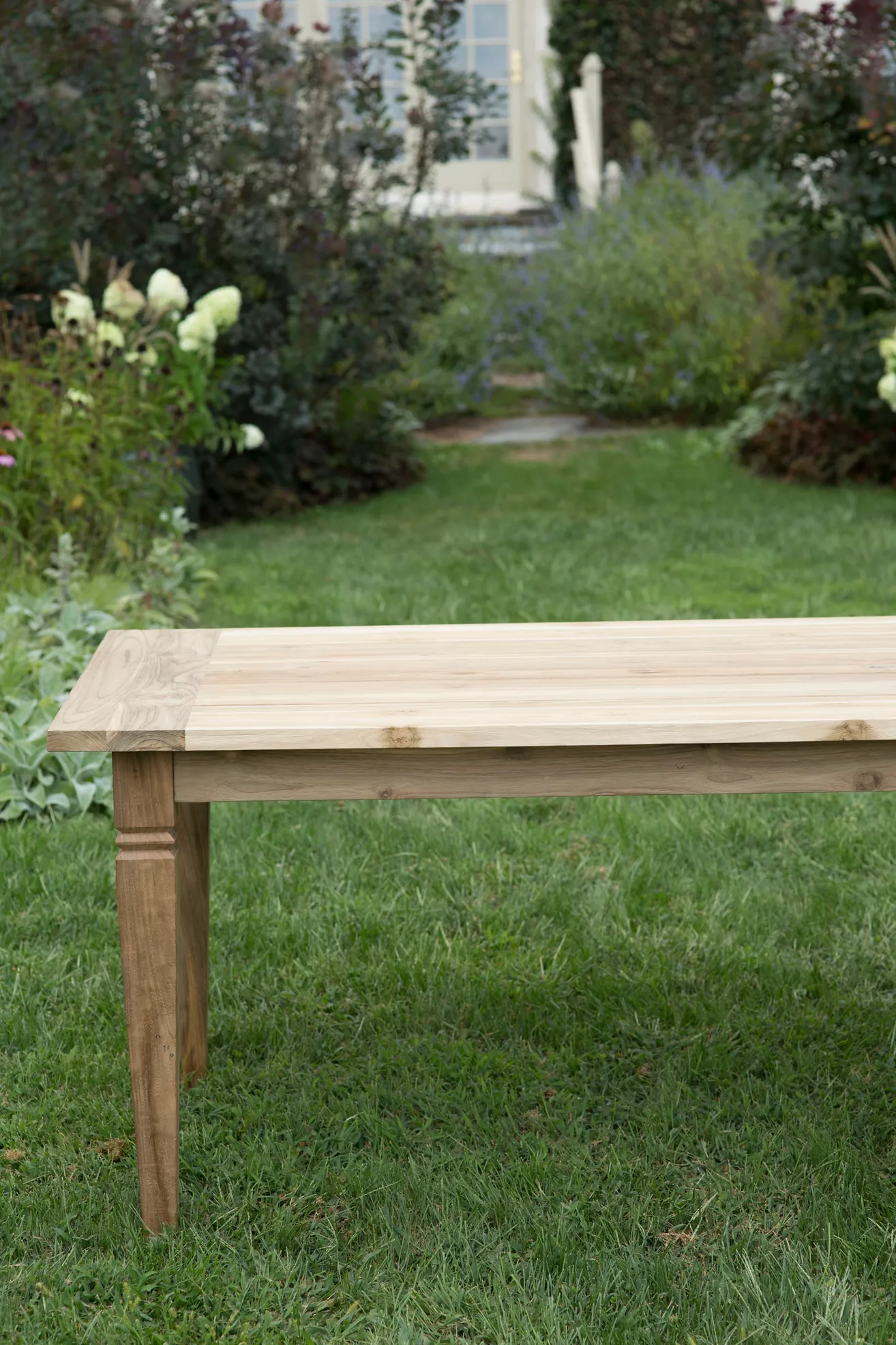 Top-down view of teak dining table in garden