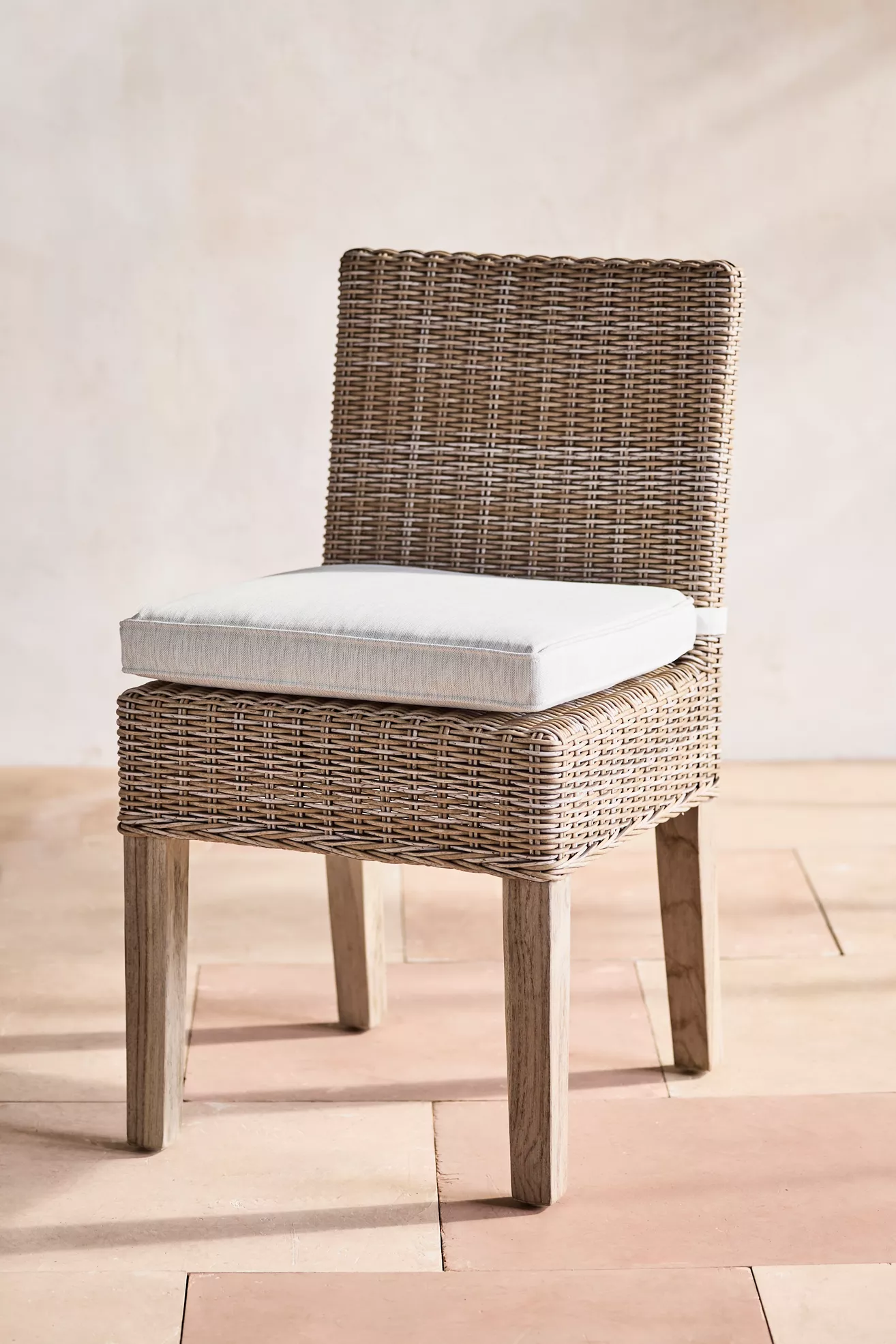 Close-up of wicker chair with cushioned seat