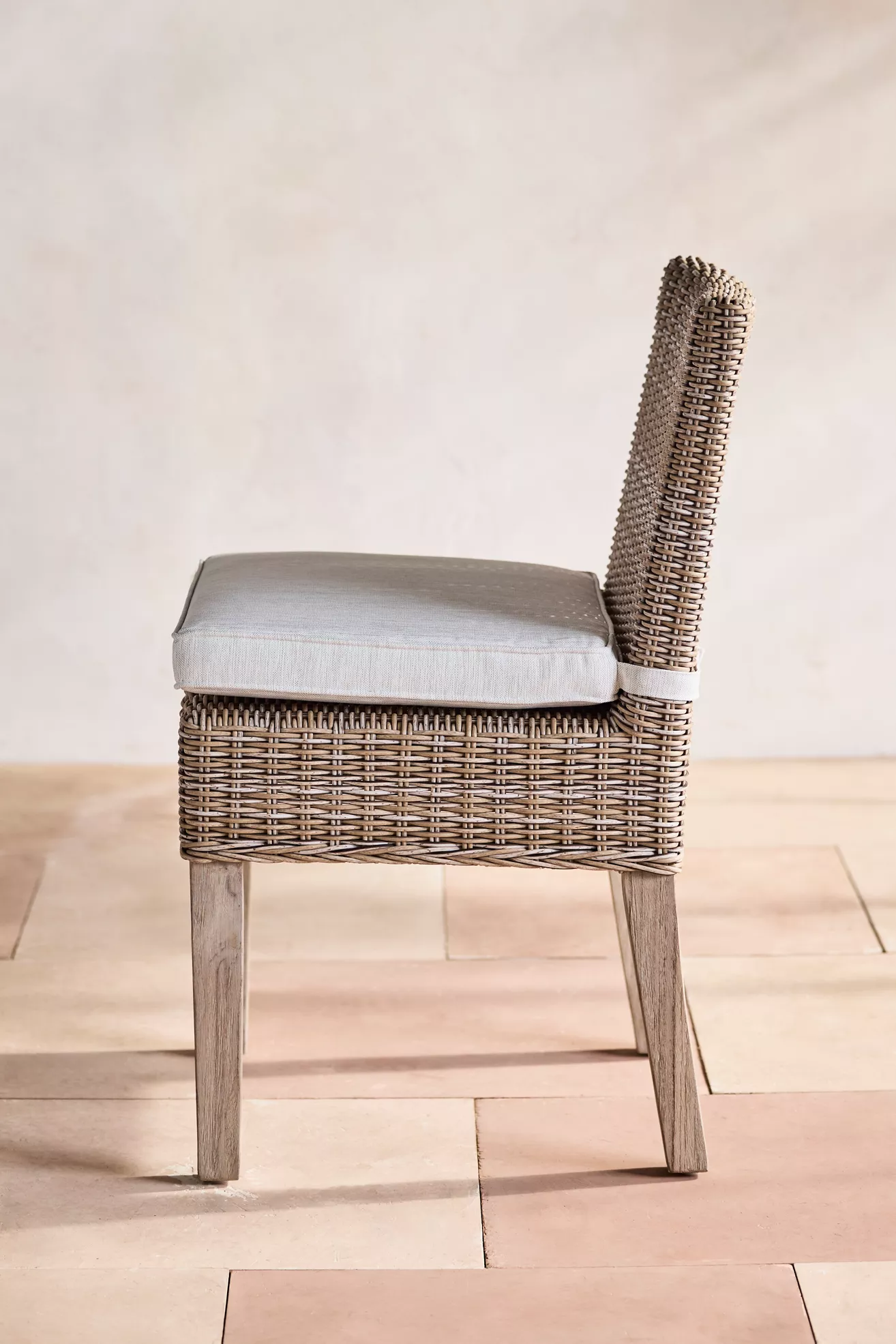 Side view of wicker chair with cushion and backrest