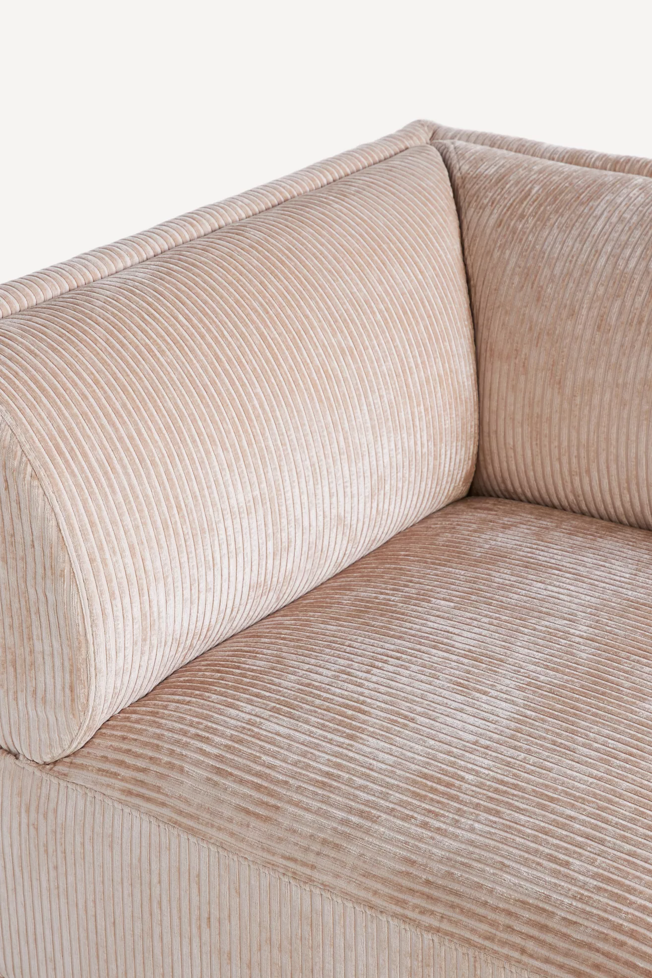 Close-up of light beige corduroy modular corner chair arm and seat upholstery.