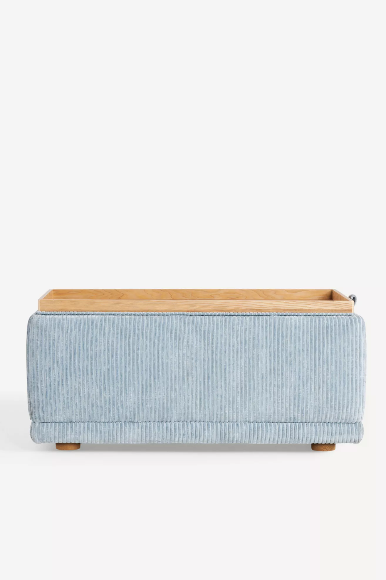 Back view of light blue corduroy storage ottoman showing lid resting on top.