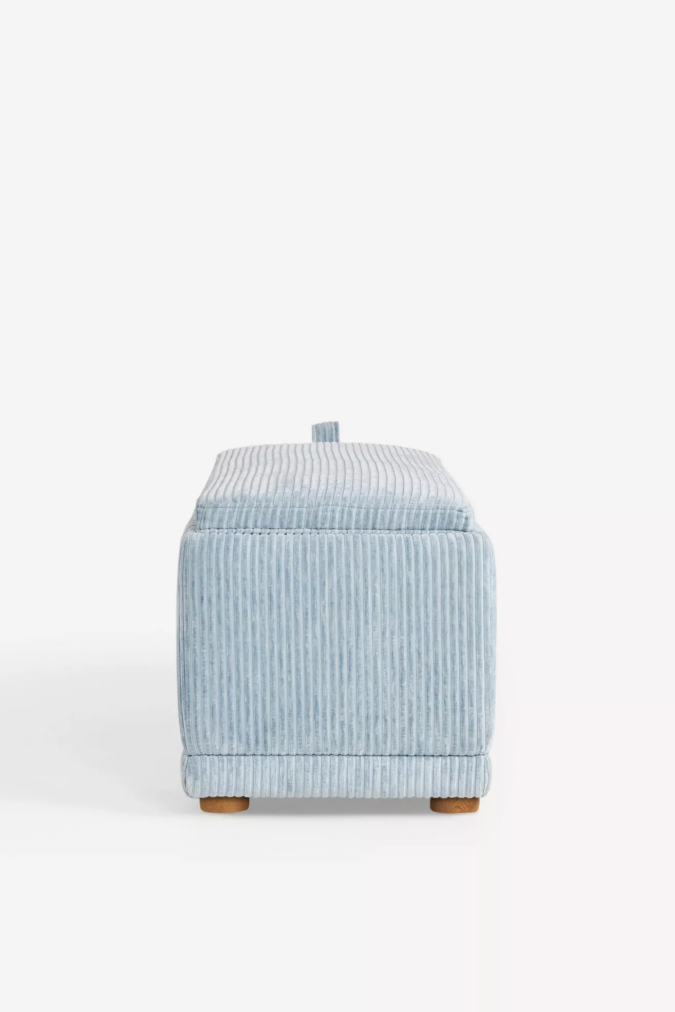 Front-left side view of light blue corduroy storage ottoman with lifting tab.