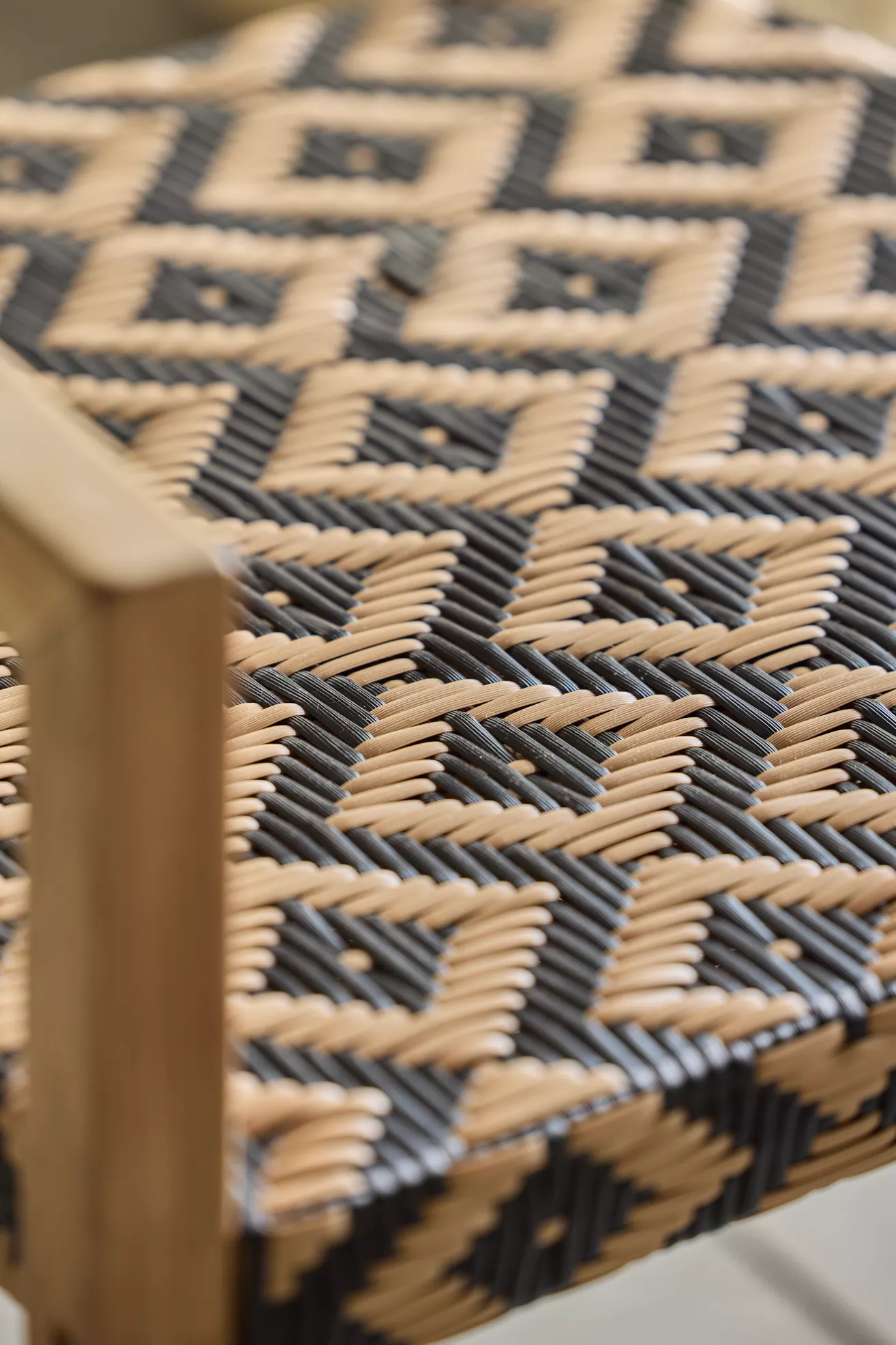 Close-up of the woven geometric pattern on the chair seat with black and natural tan fibers