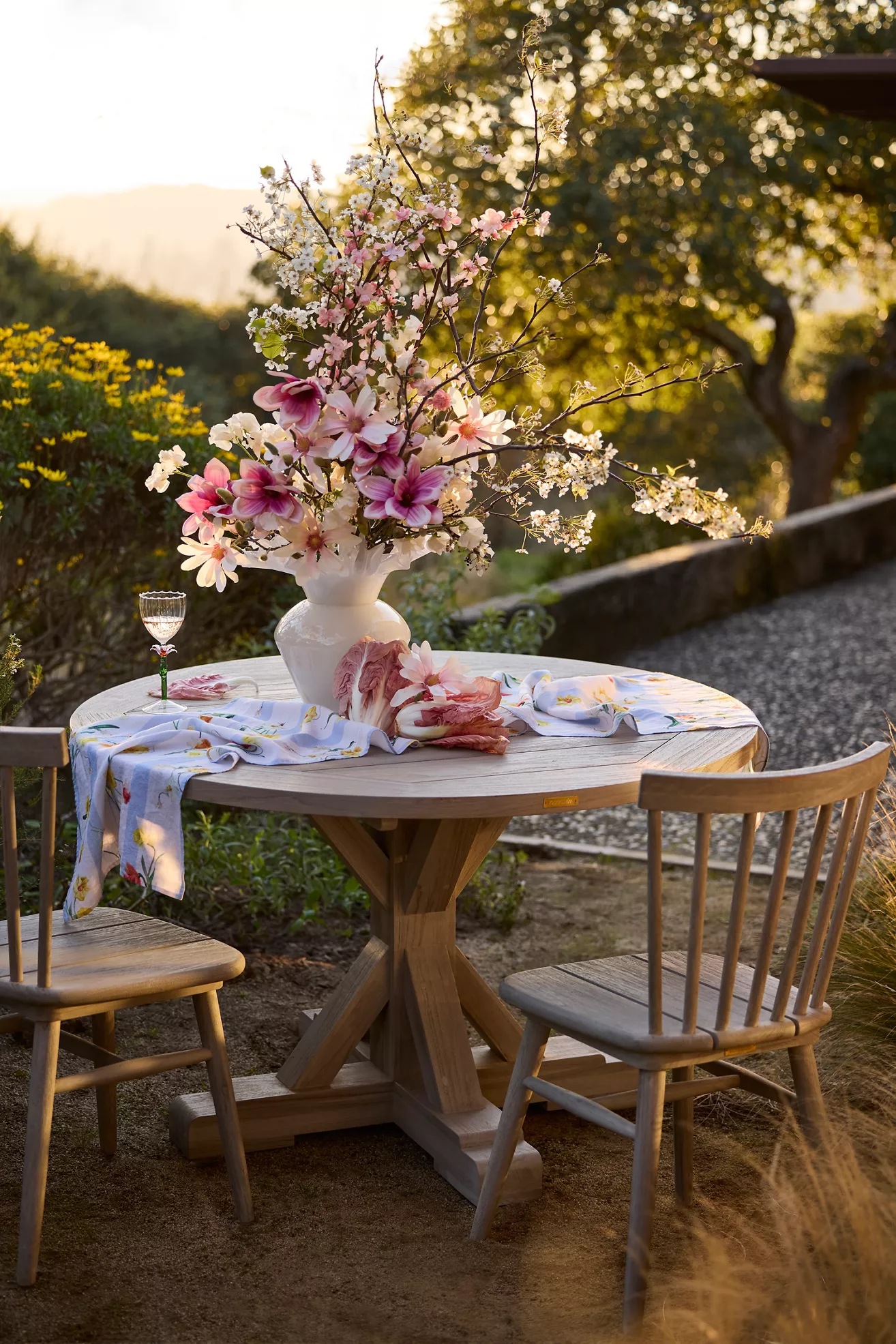 Outdoor dining setup with light gray wood chairs and a table