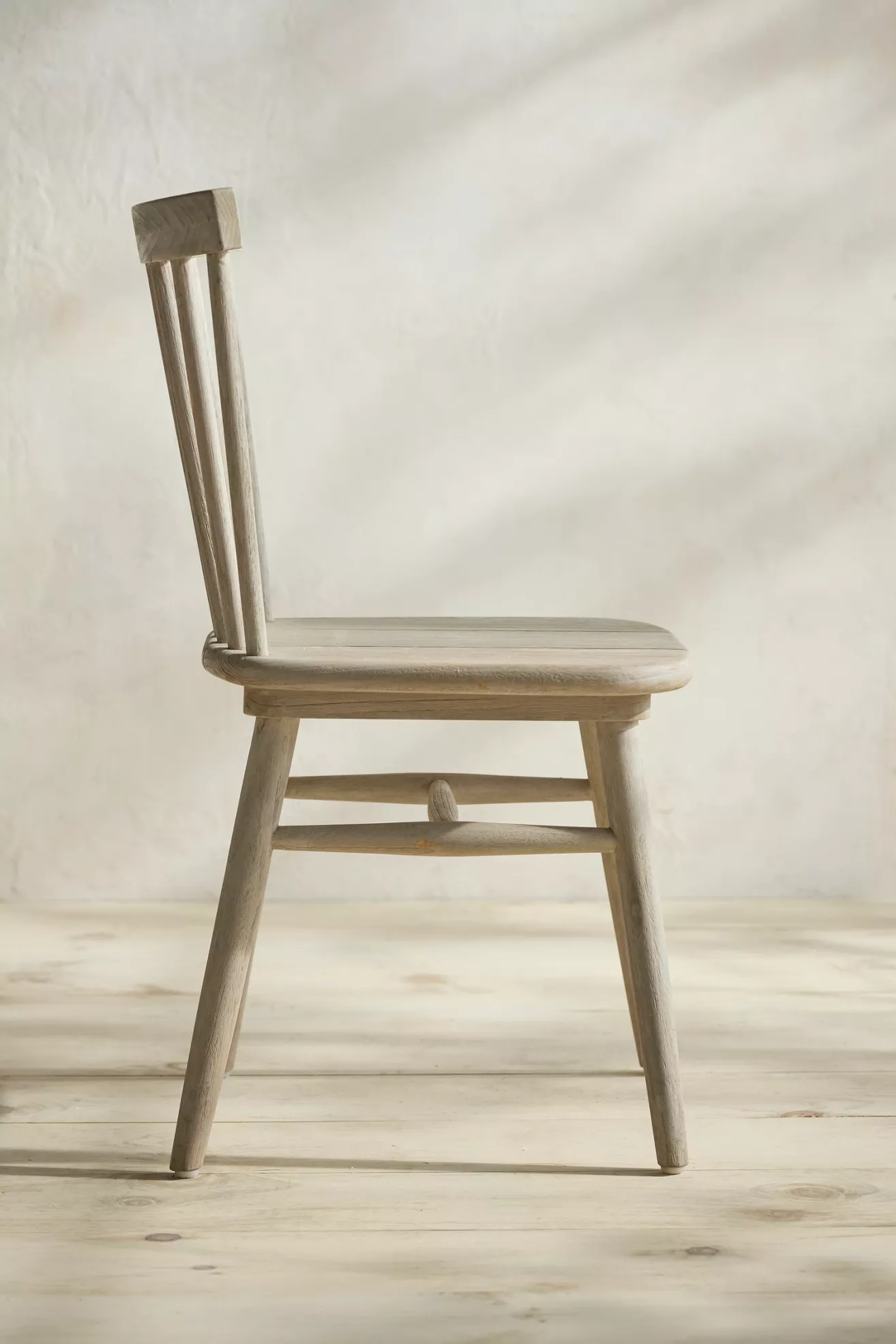 Side view of light gray wood chair with tall slat back