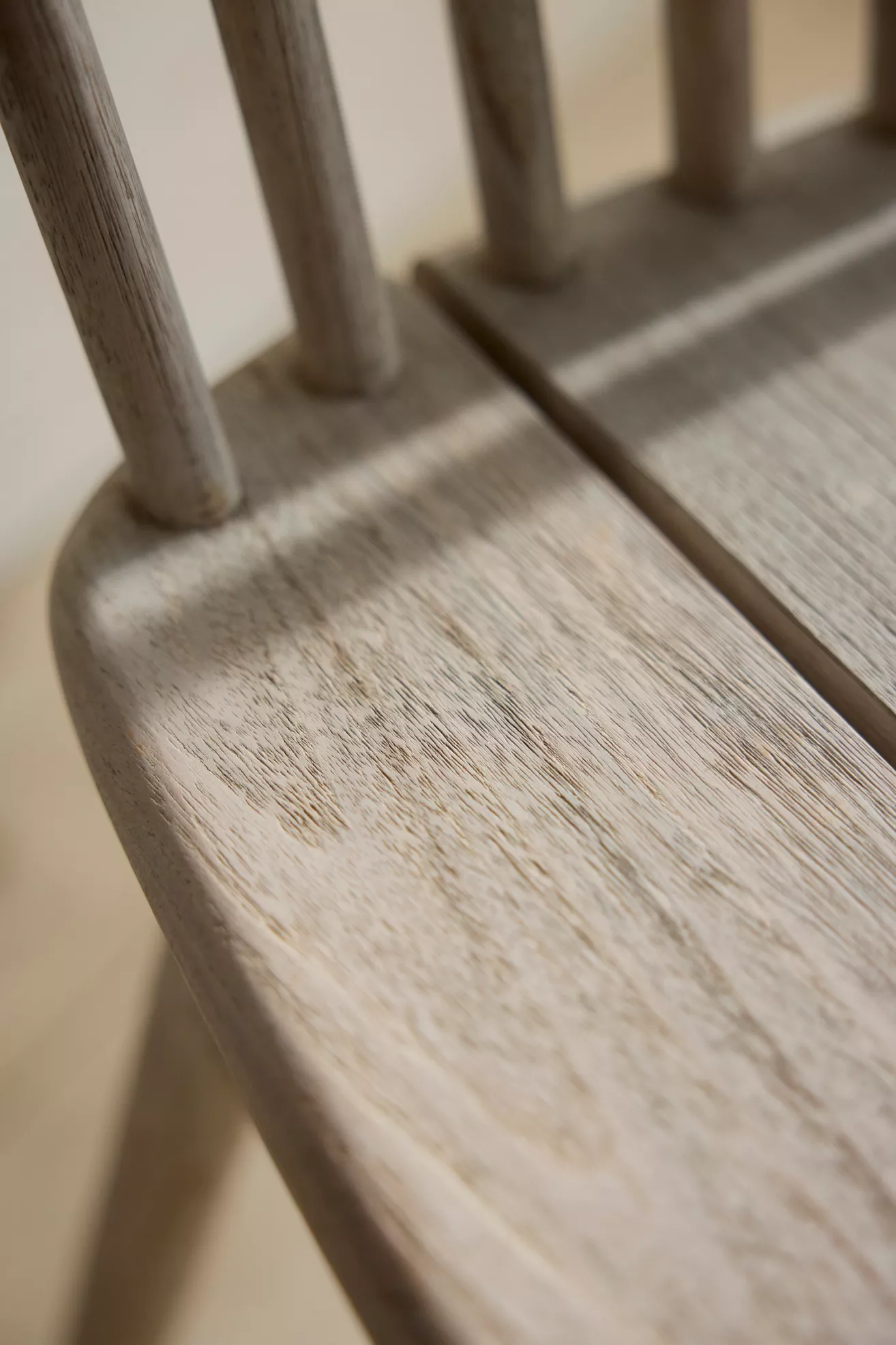 Close-up of light gray chair seat with visible wood grain texture