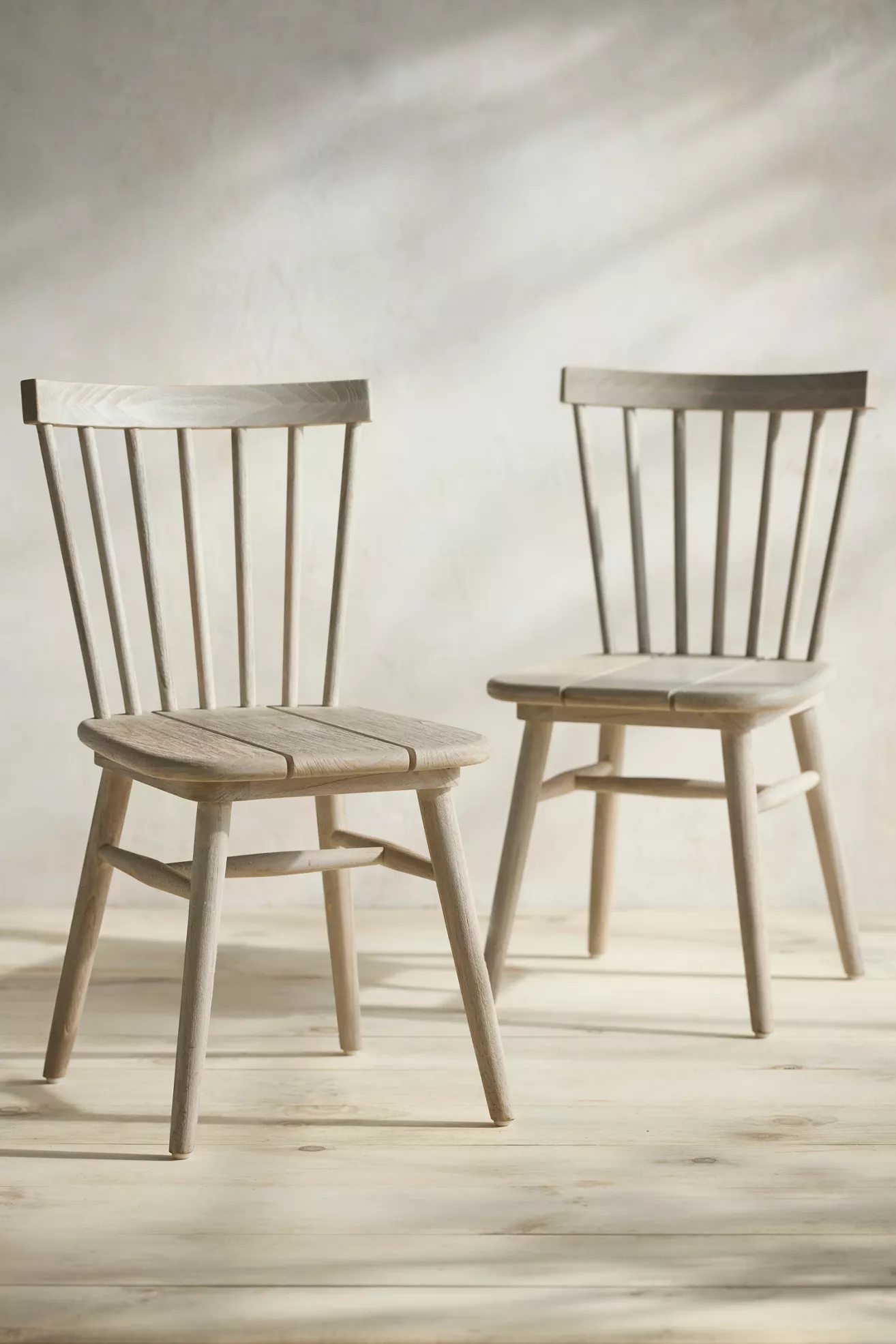 Two light gray wood side chairs with vertical slat backs and cushioned seats