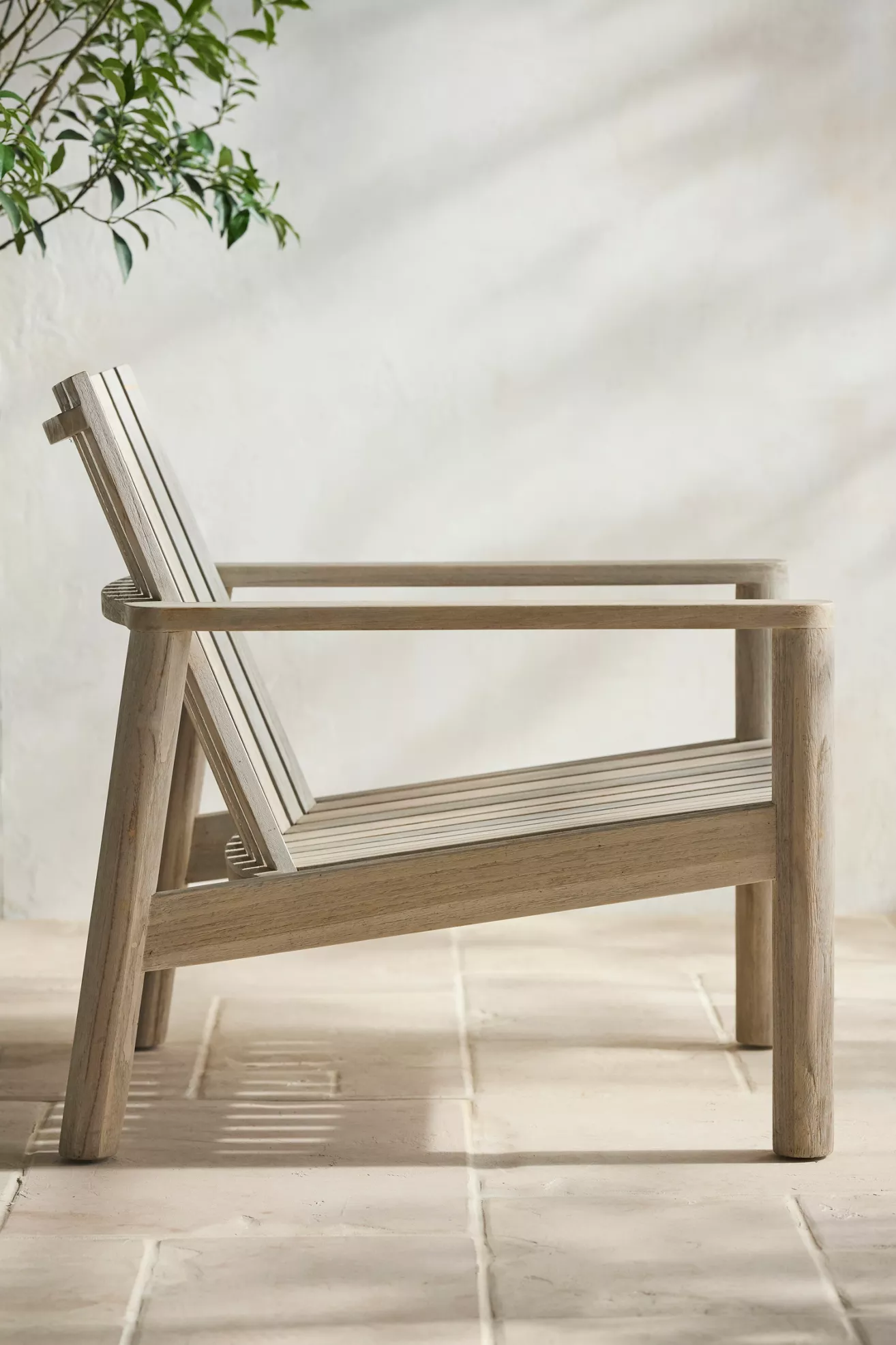 Side view of teak chair showing armrest and slats