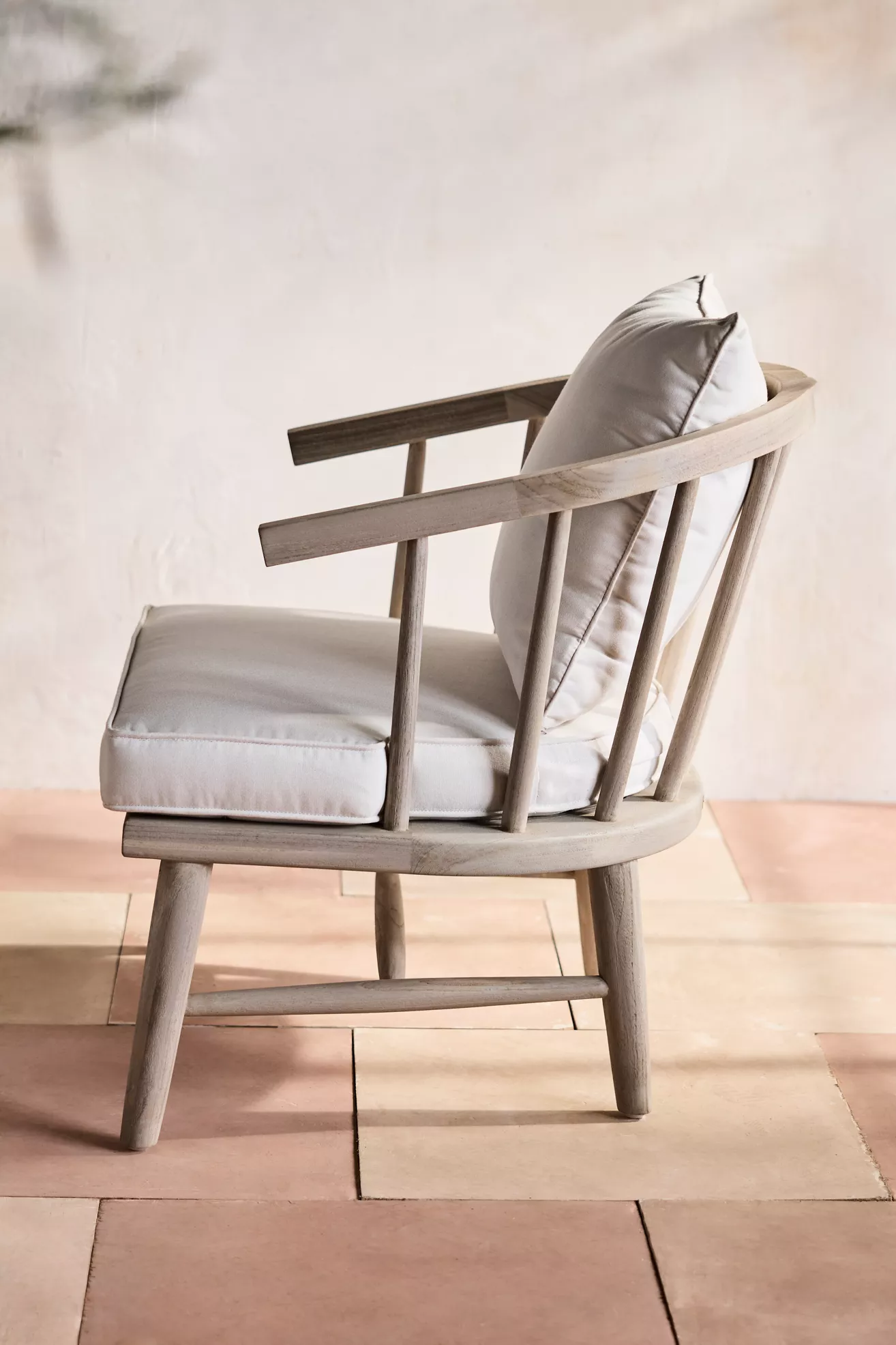 Side view of terrace teak lounge chair with cushions